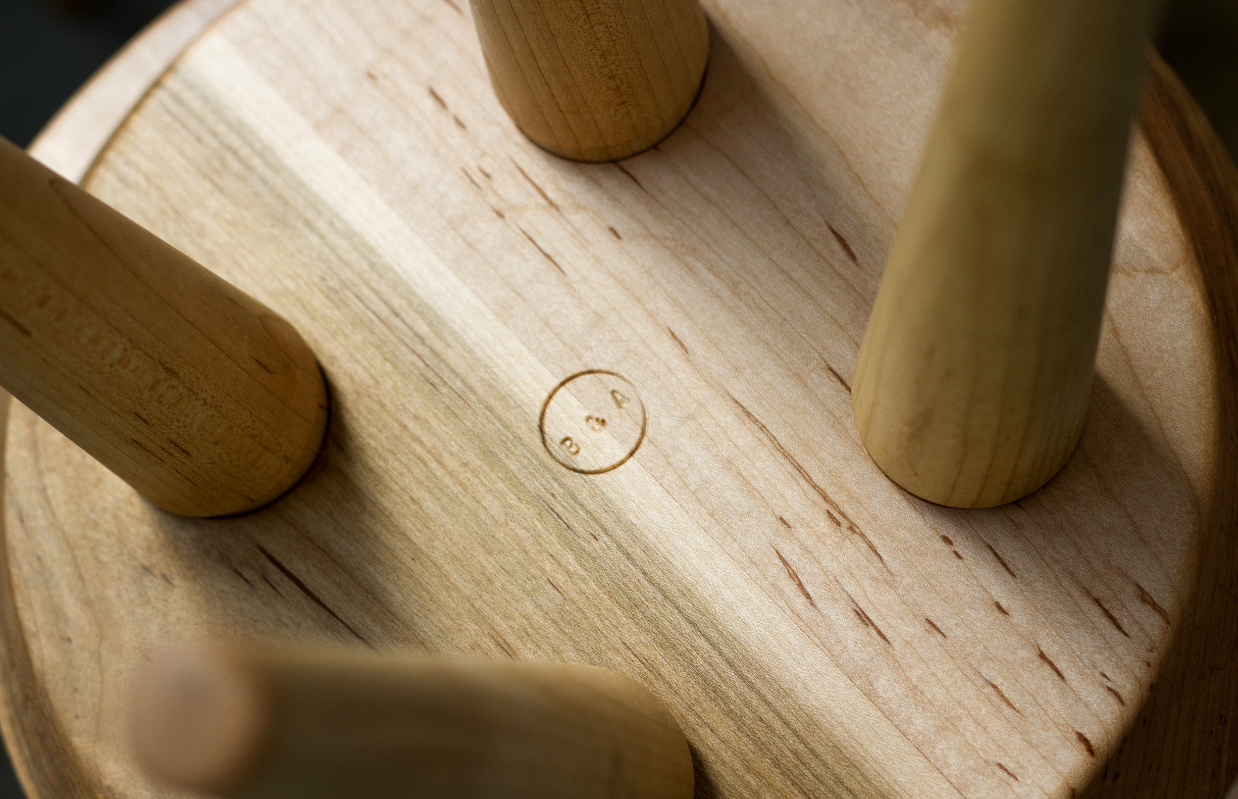 Custom designed Shaker-style maple display stools with wedged through tenon legs, brand detail.