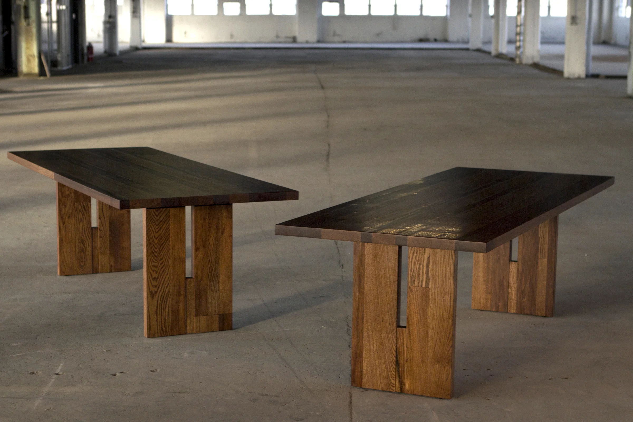 Set of custom oak and butternut dining tables with aluminum bar inlay and trestle legs.