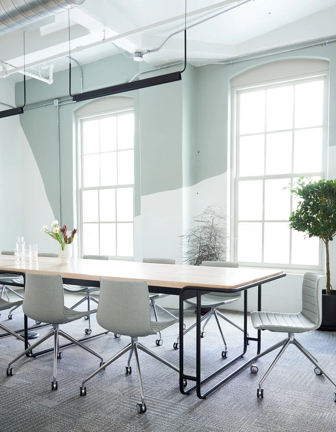 Custom designed conference table with bent steel tube base and solid maple top.