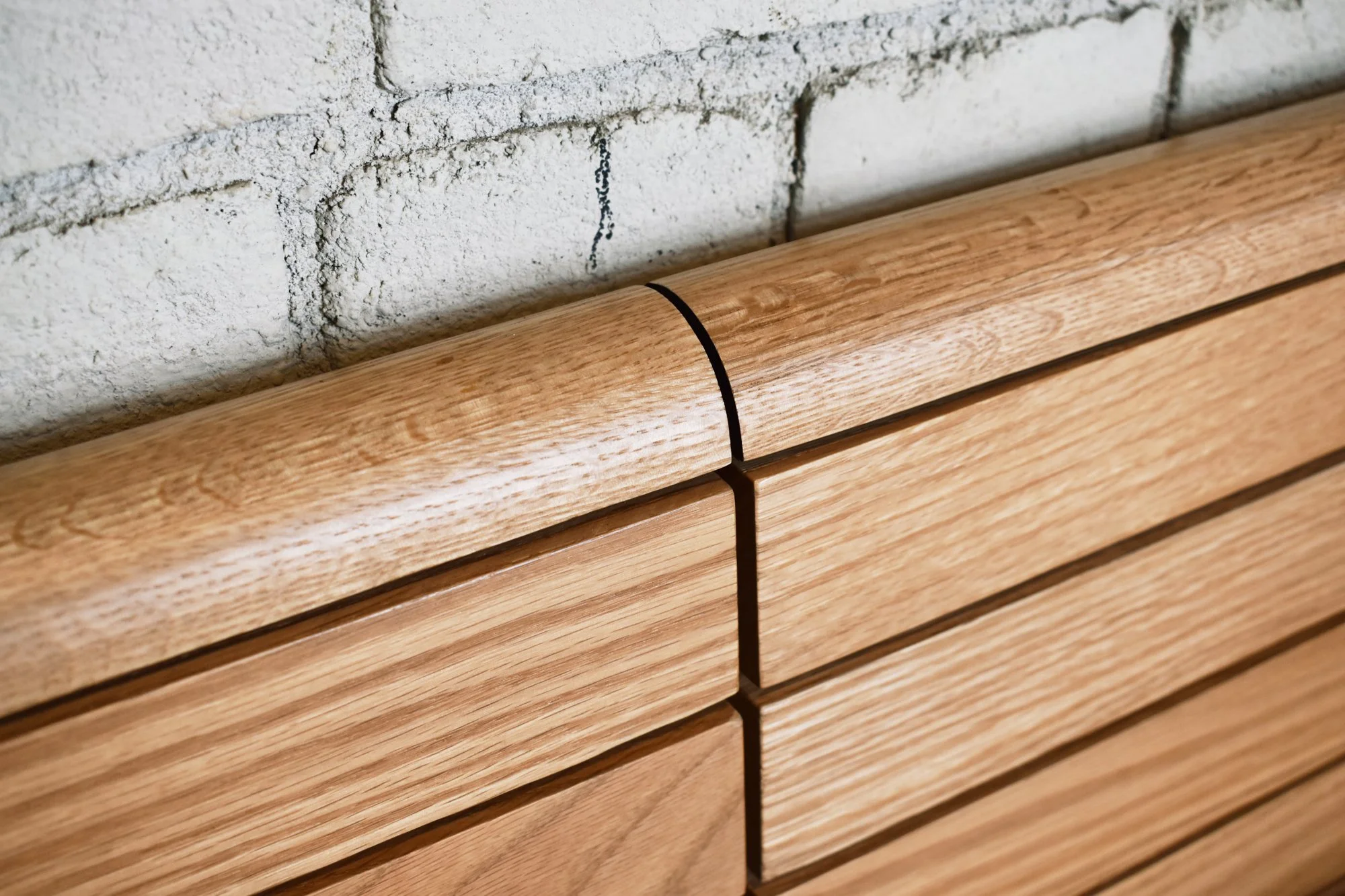 Custom red oak banquette seating with integrated storage, seat back bullnose detail.