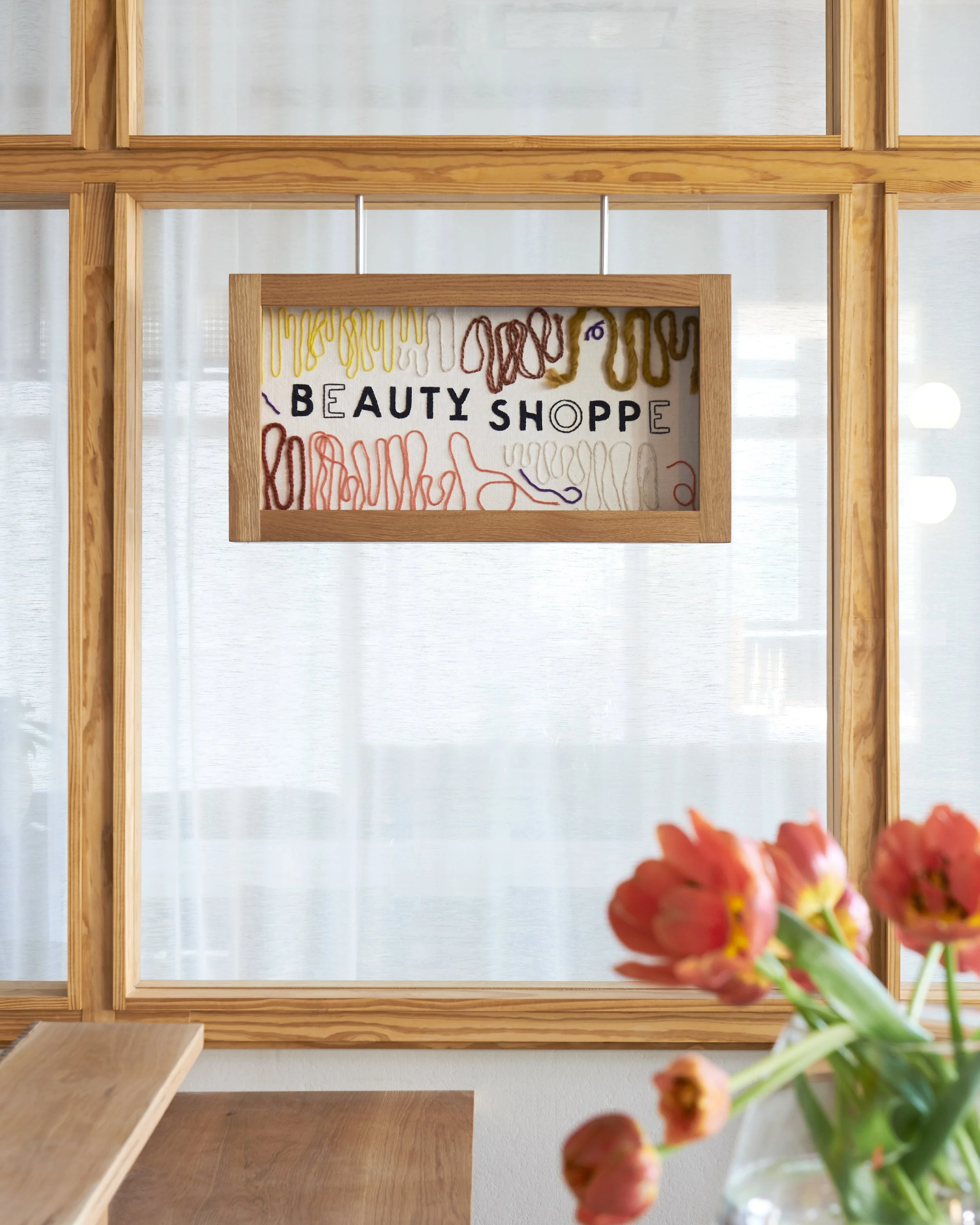 Custom fabric sign in white oak frame embroidered and couched by Kelsey Henson.