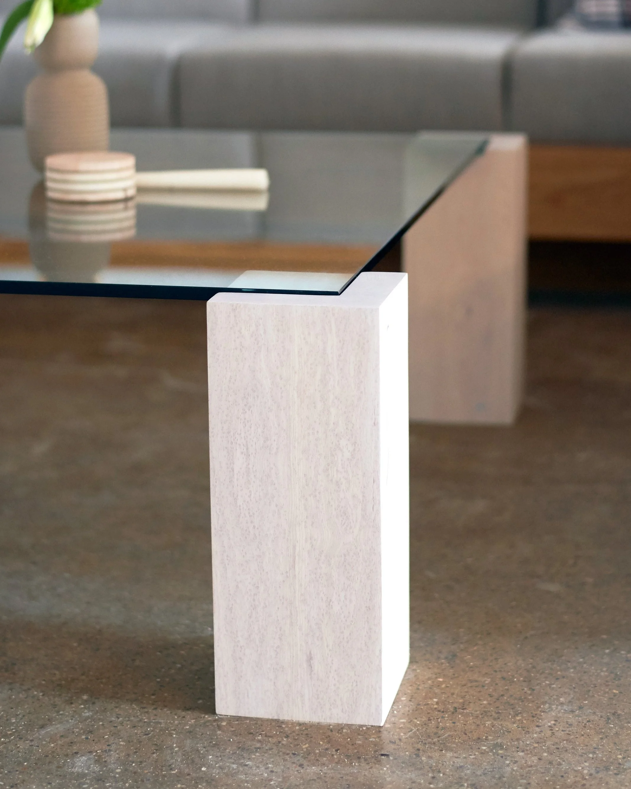 Custom designed coffee table with birdseye maple pillar legs and inset tempered glass top.