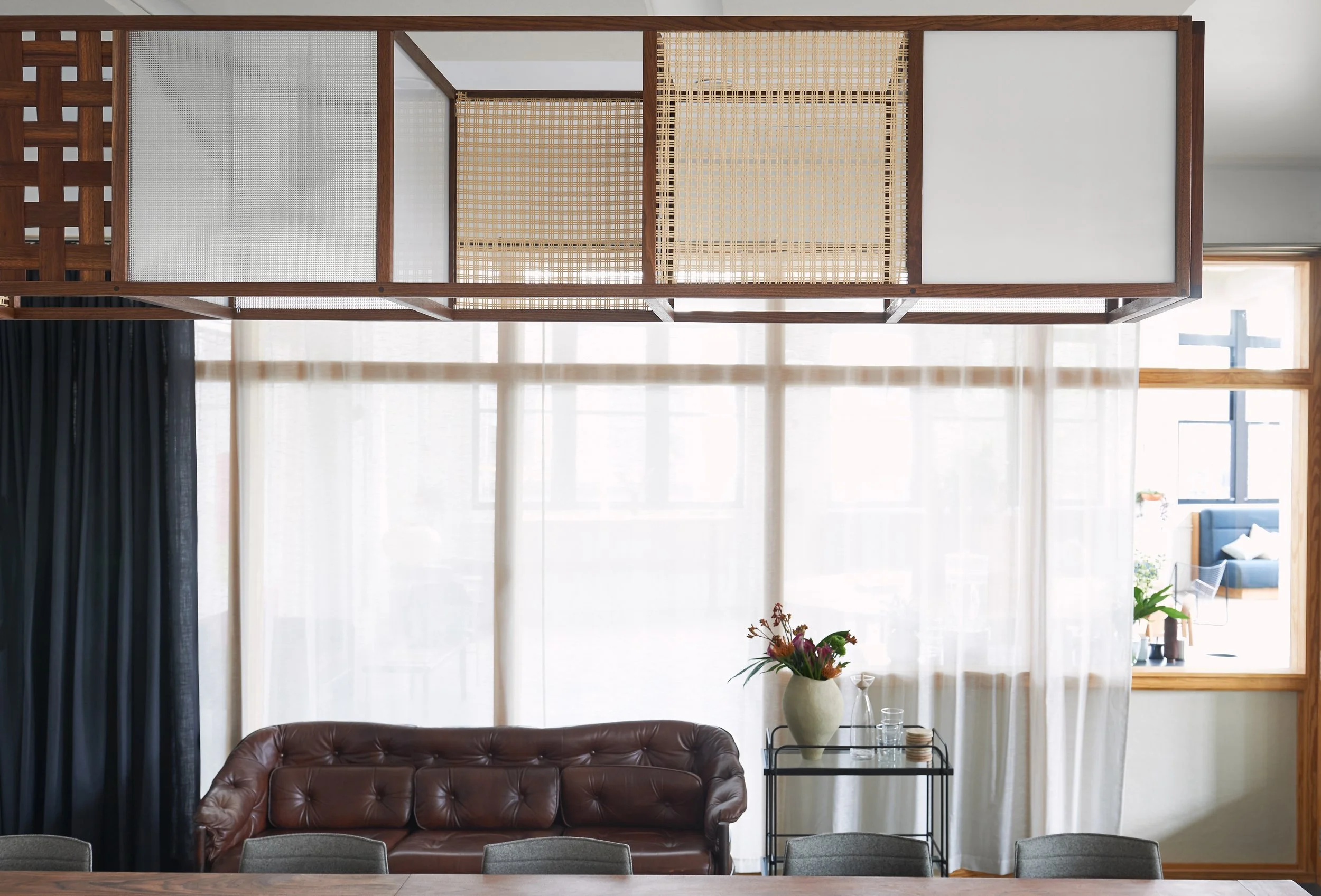 Custom walnut light shade with woven walnut, textured and milk glass, and caned panels.
