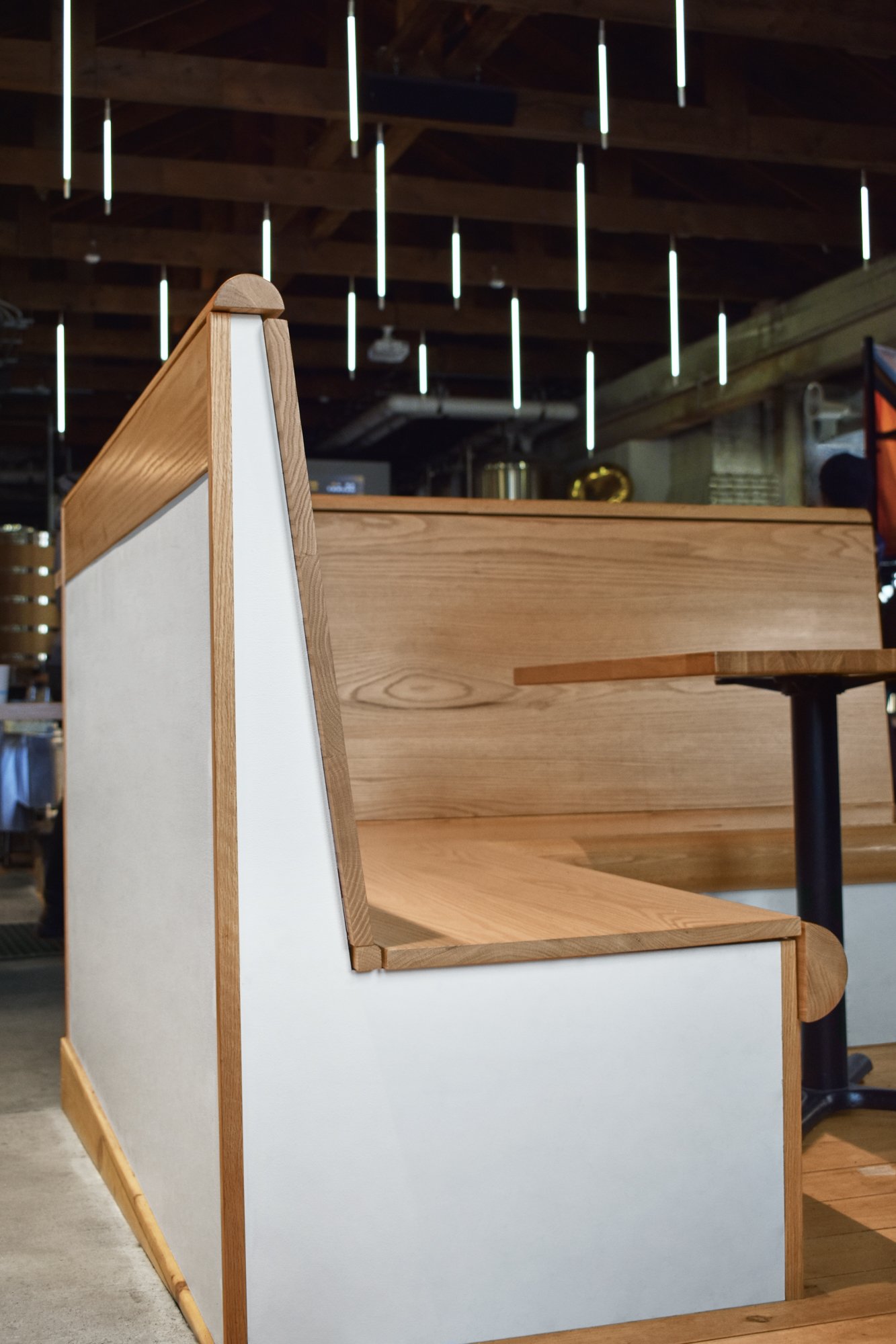 Custom red oak banquette seating with integrated storage, side detail.