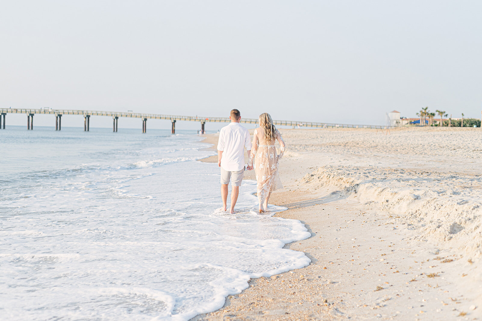  Couple walking on St. Augustine Beach for engagement photos 