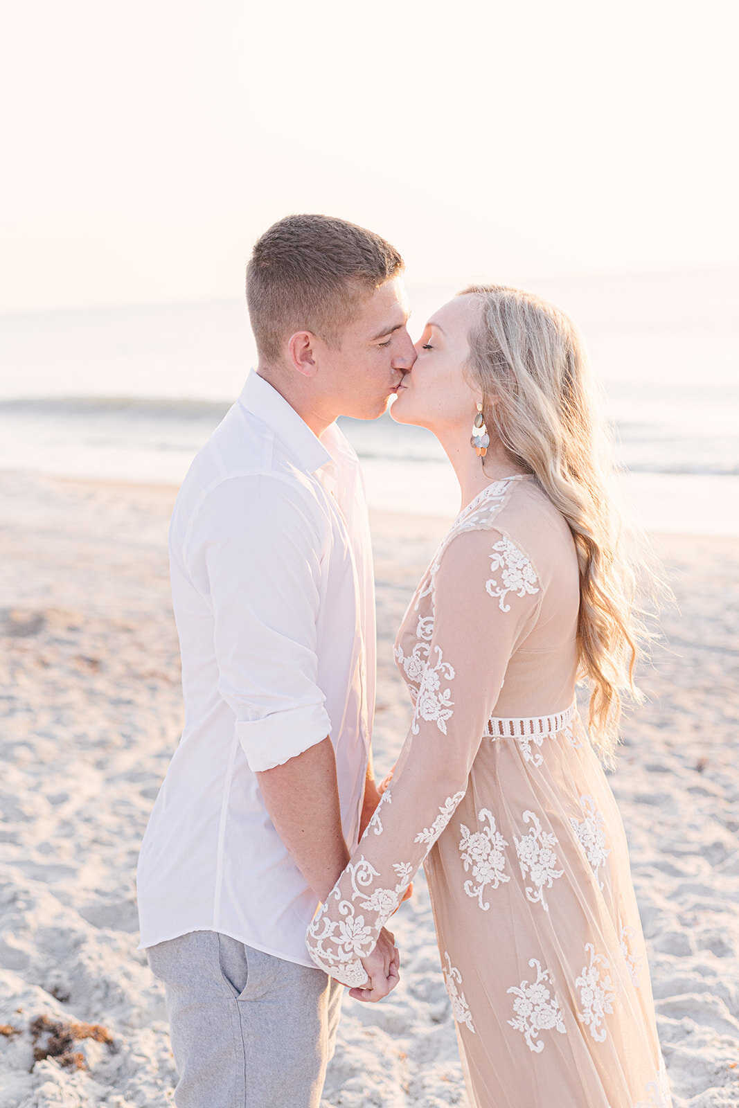  couple kissing on beach for engagement photos 