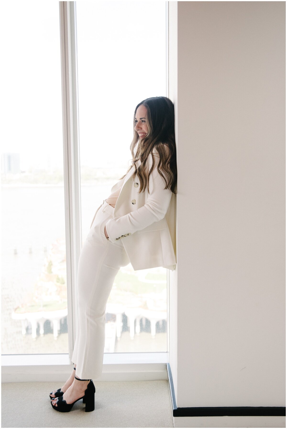  Fun brand shoot pose, woman in white in front of window, leaning on wall 