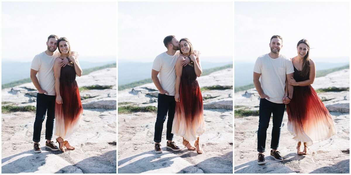Man putting arm around woman | Man kissing woman on forehead | Couple standing next to each other during Minnewaska State Park engagement session | NKB Photo