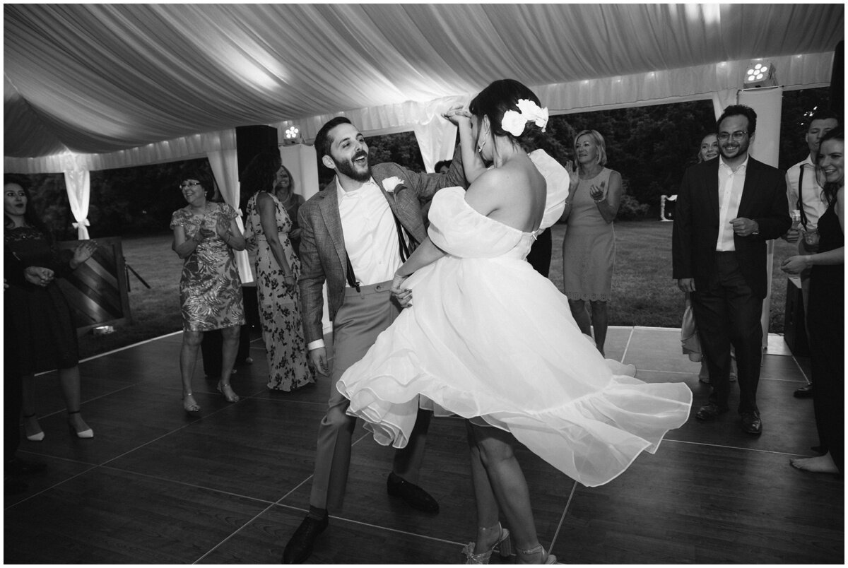  black and white photo of bride twirling on dance floor at private estate wedding 