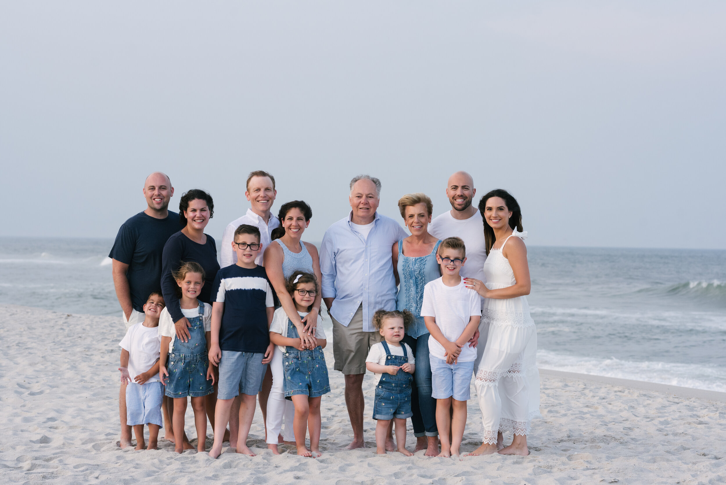 Beach photo ideas: extended family standing on beach during family photos | NKB Photo