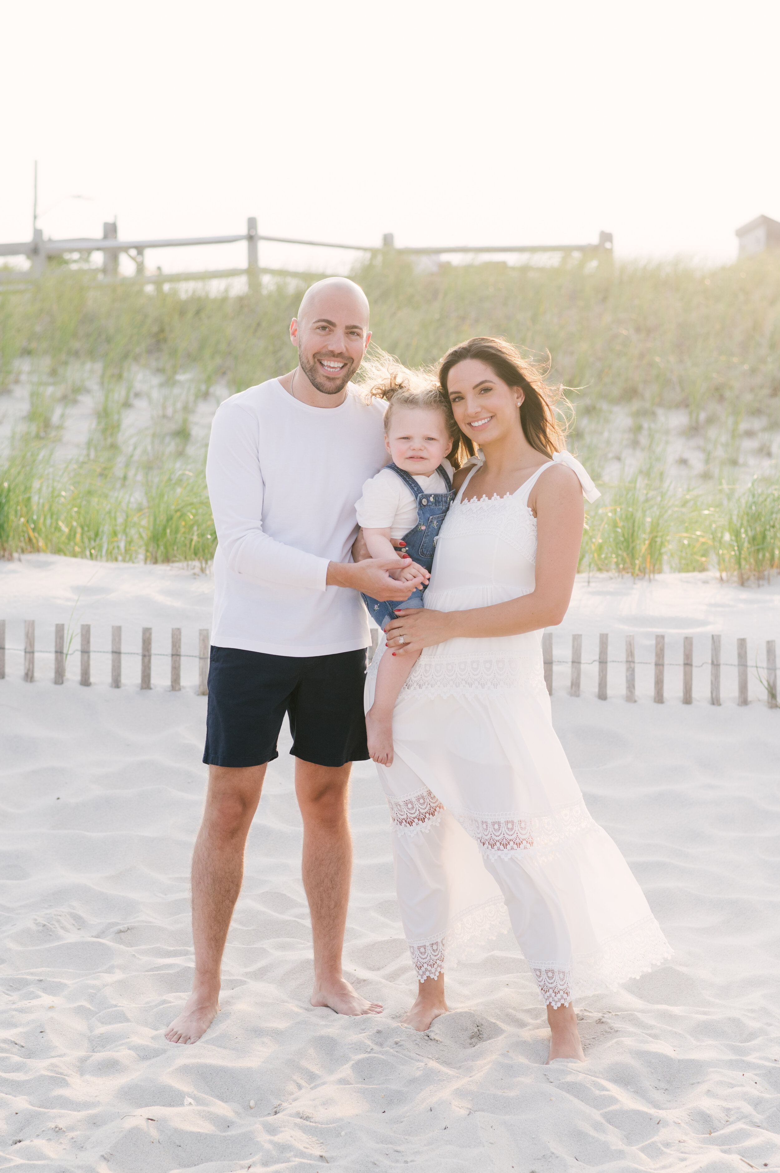 Mom, dad, and daughter in denim and white during beach photos  | NKB Photo