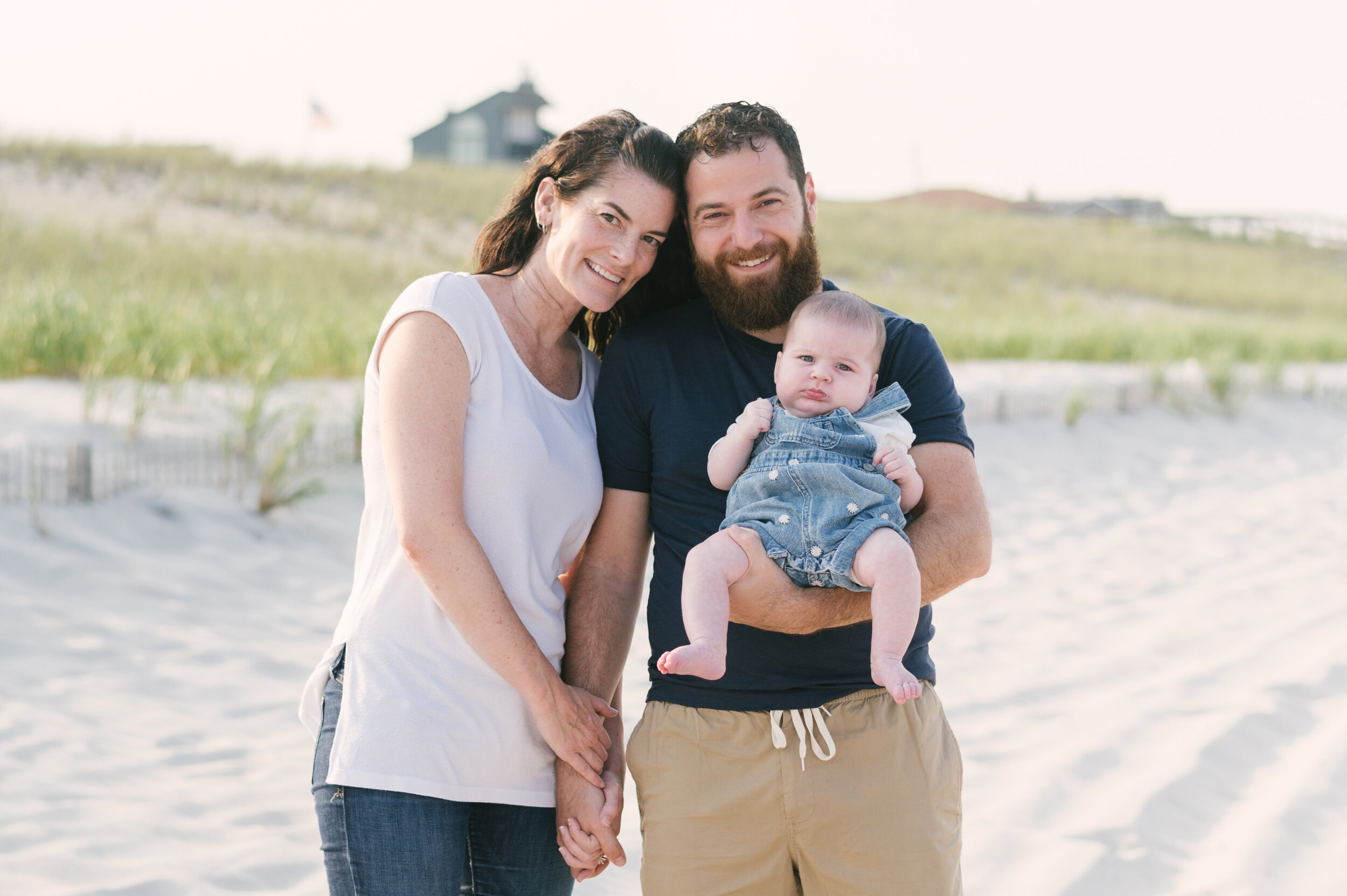 Mom, dad, and baby standing on beach during family beach photos  | NKB Photo
