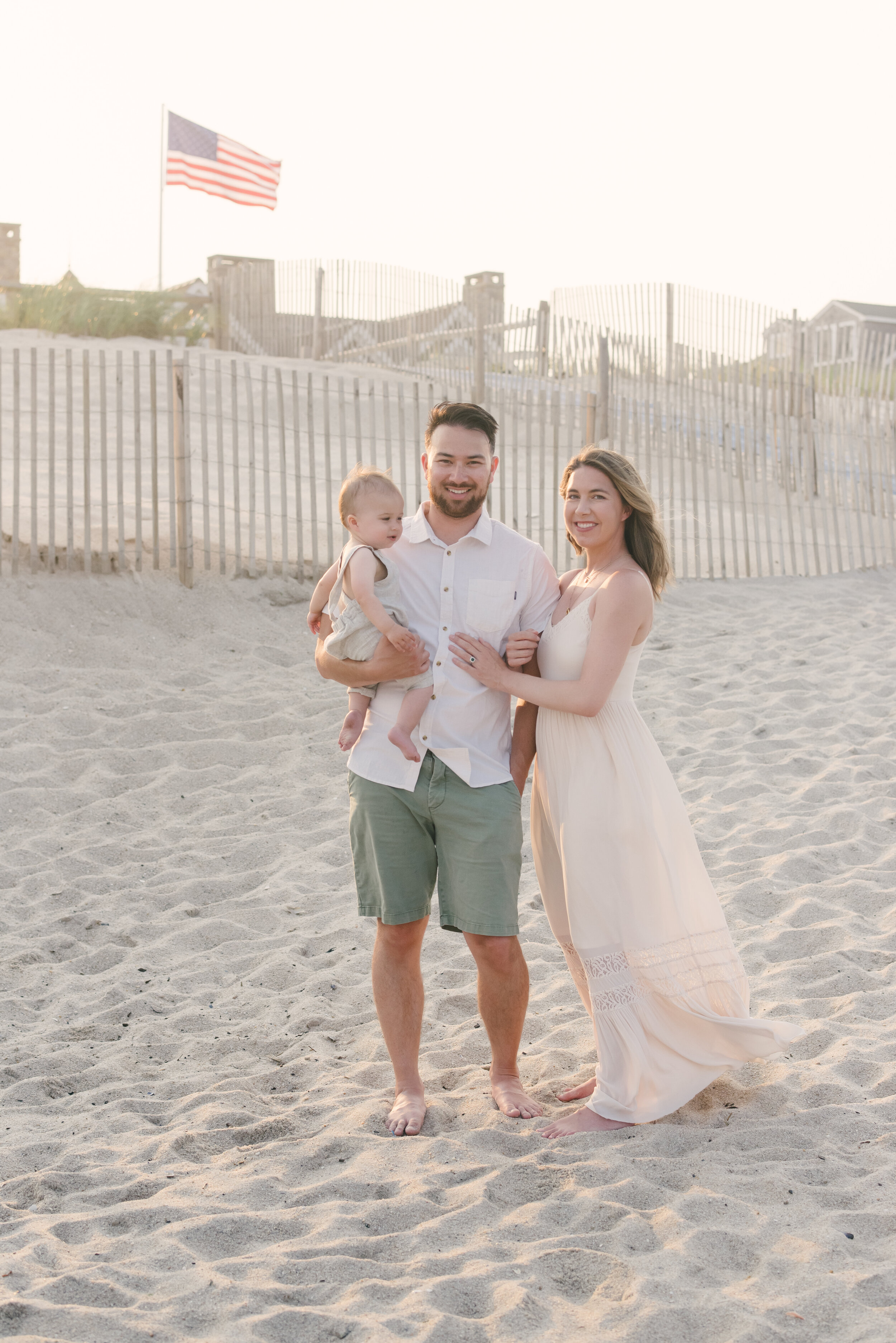 Mom, dad, and baby standing on beach during family photos | NKB Photo