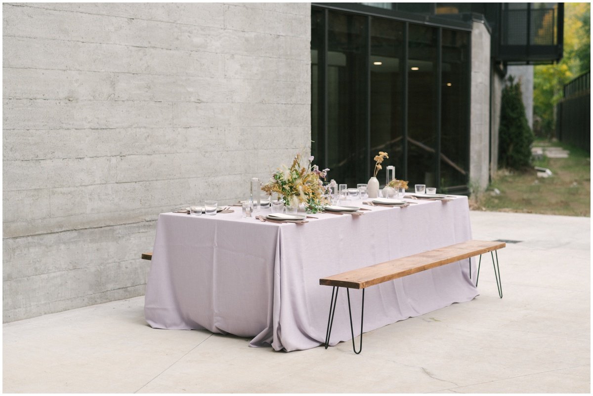 Pale purple table cloth with gold and purple floral arrangements for beach elopement inspired shoot | NKB Photo