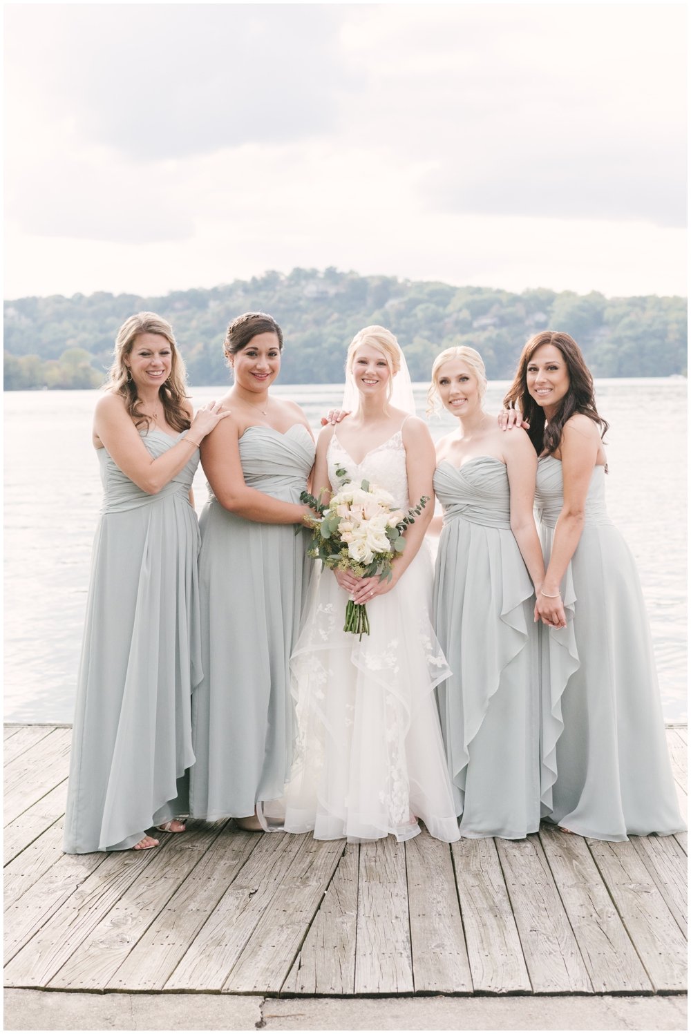 Bride standing with bridesmaids on dock before Lake Mohawk Country Club Wedding | NKB Photo
