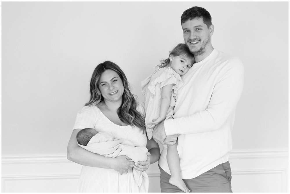 Black and white image of family posing during newborn session | NKB Photo