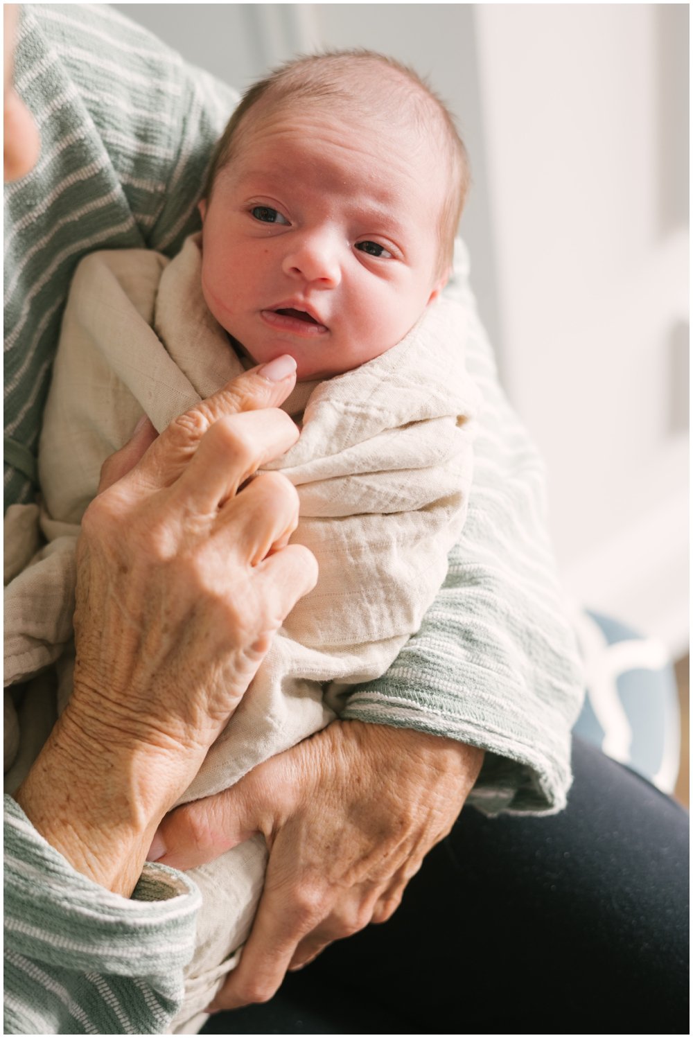 Grandma holding newborn with eyes open during session | NKB Photo