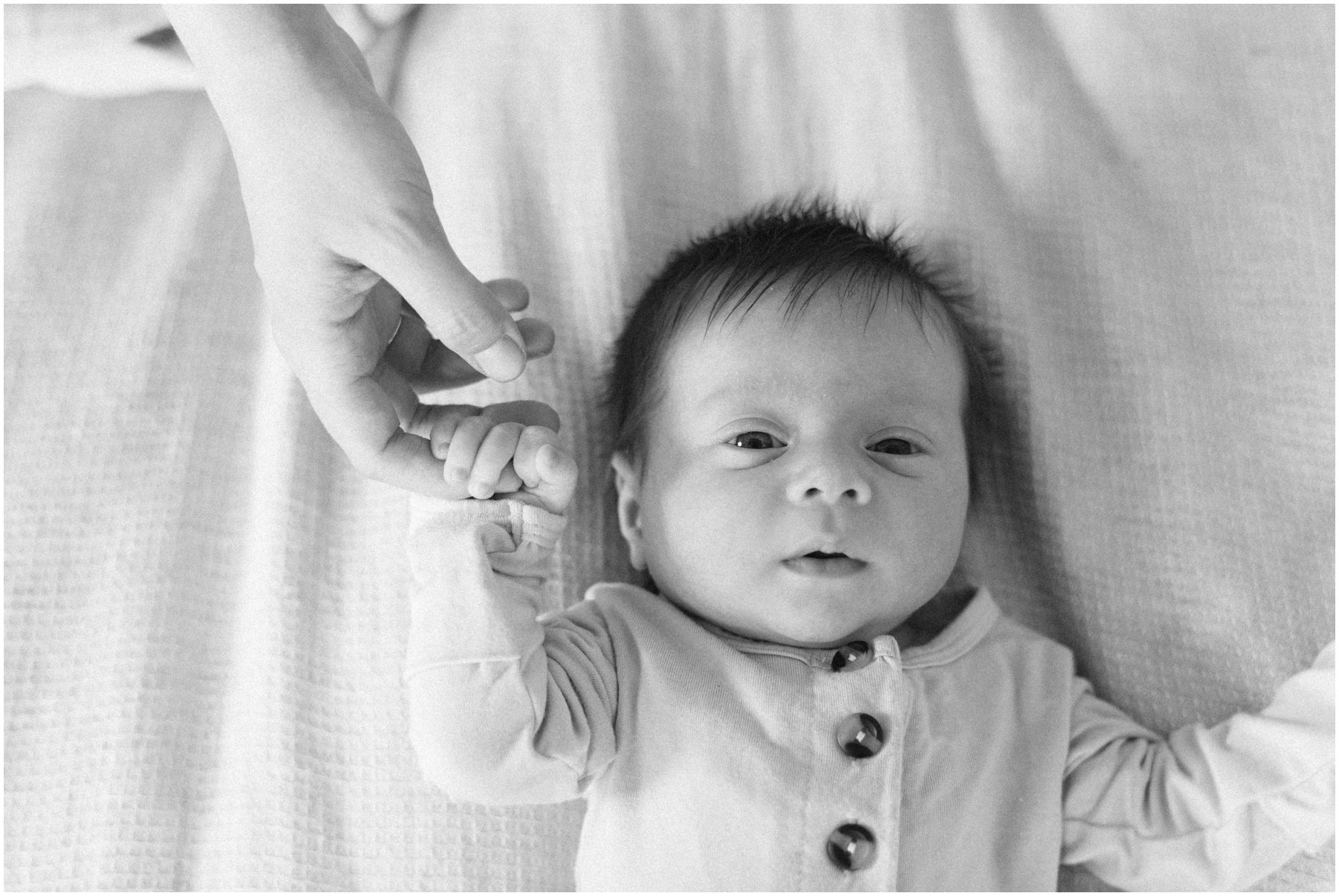 Newborn holding mom's finger during  Florida milestone photography | NKB Photo