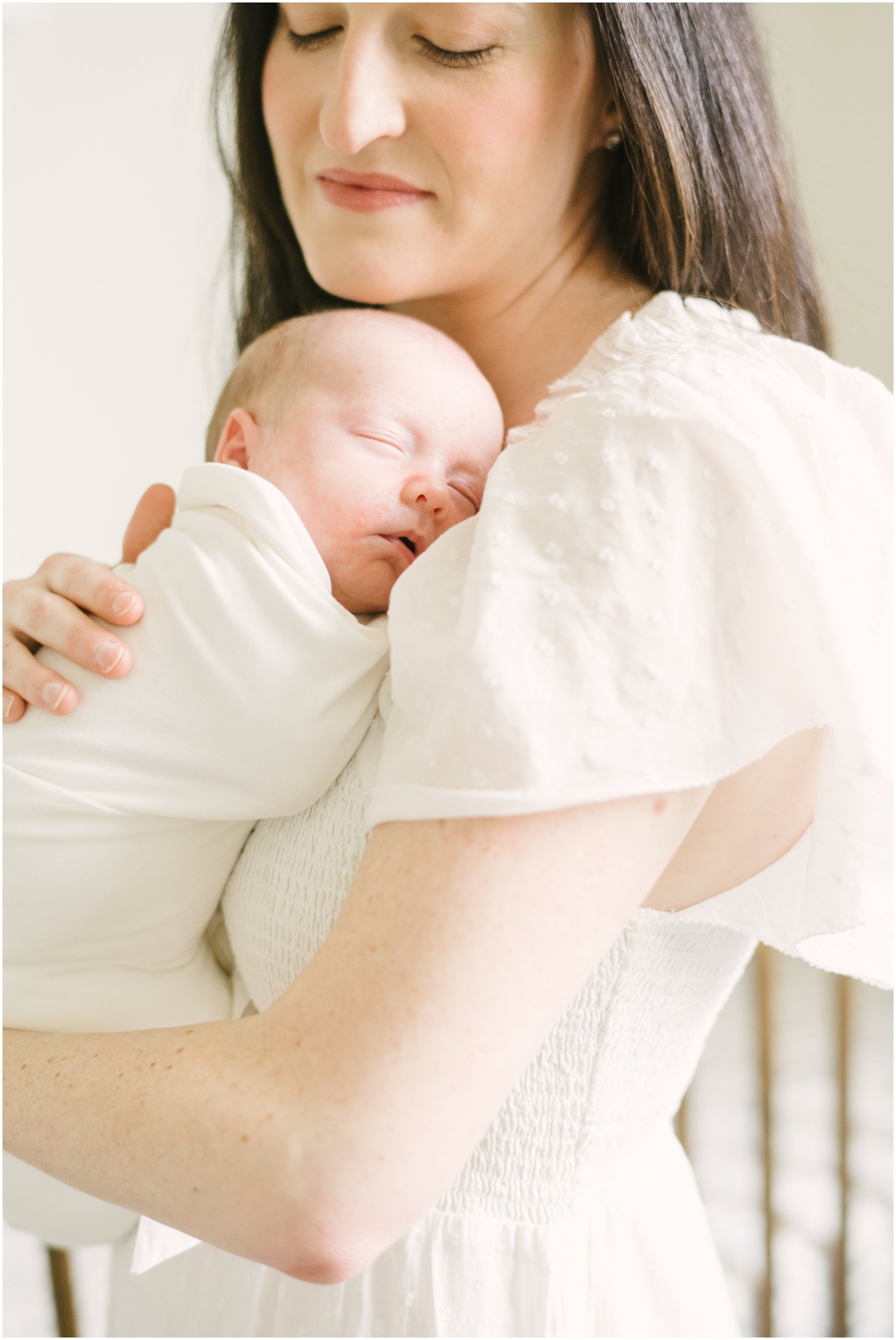 Mom holding sleeping baby on chest during newborn session | NKB Photo