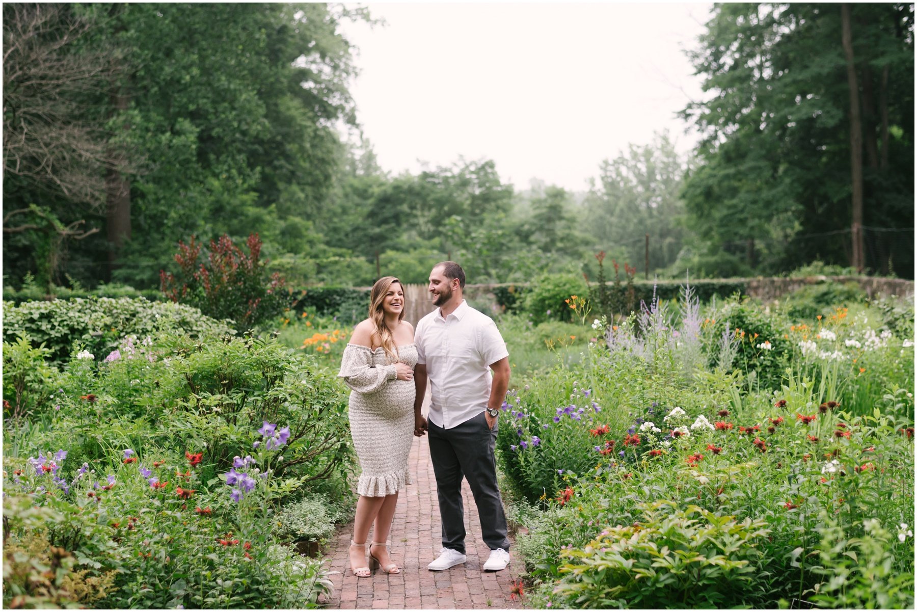 Couple laughing in garden during maternity session | NKB Photo
