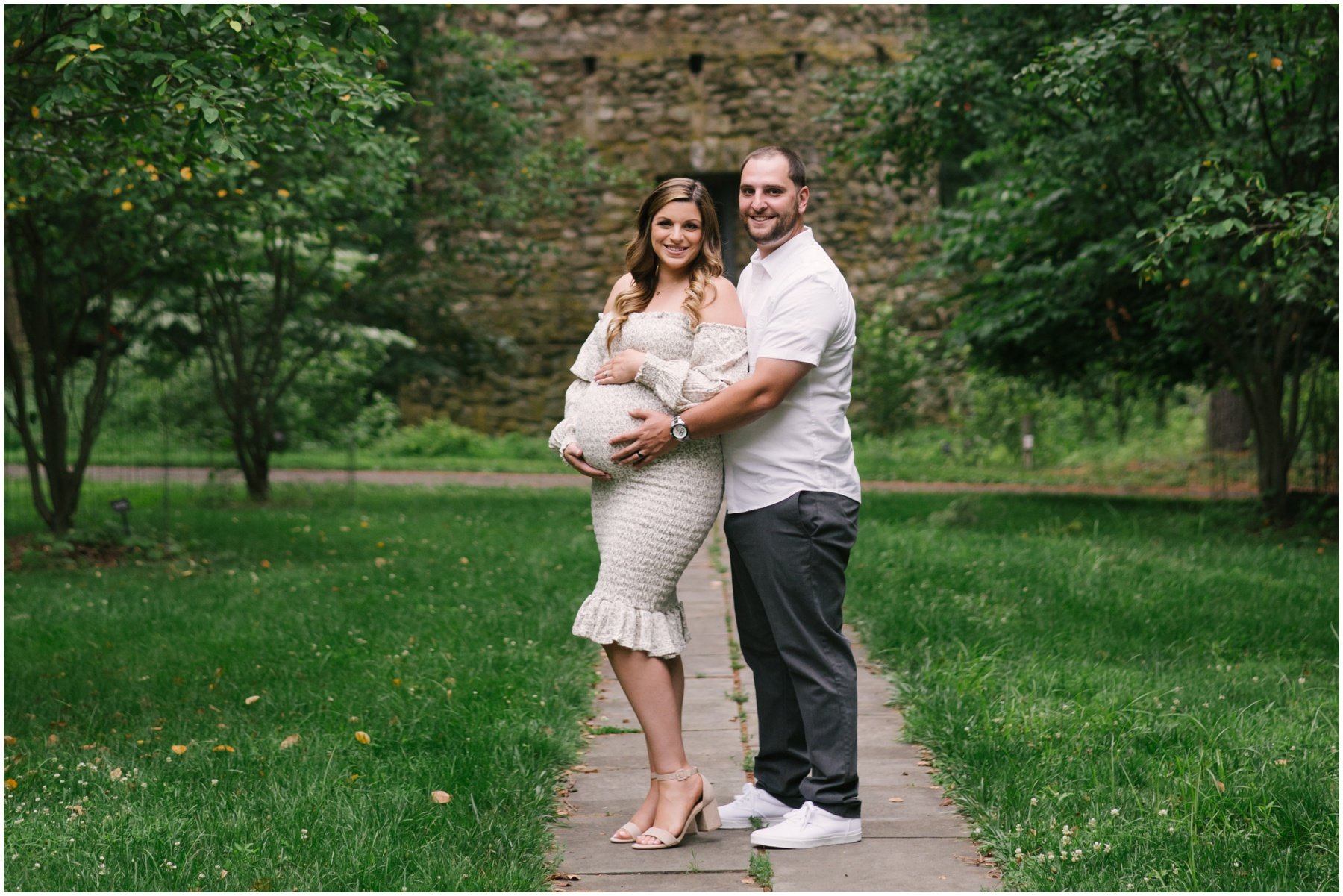 Man standing behind woman with hands on pregnant belly during maternity session | NKB Photo
