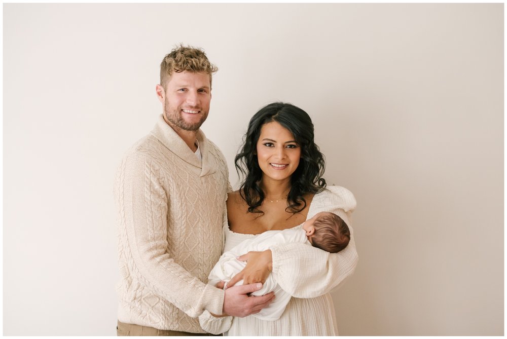 Mom, dad, and newborn smiling during newborn session | NKB Photo