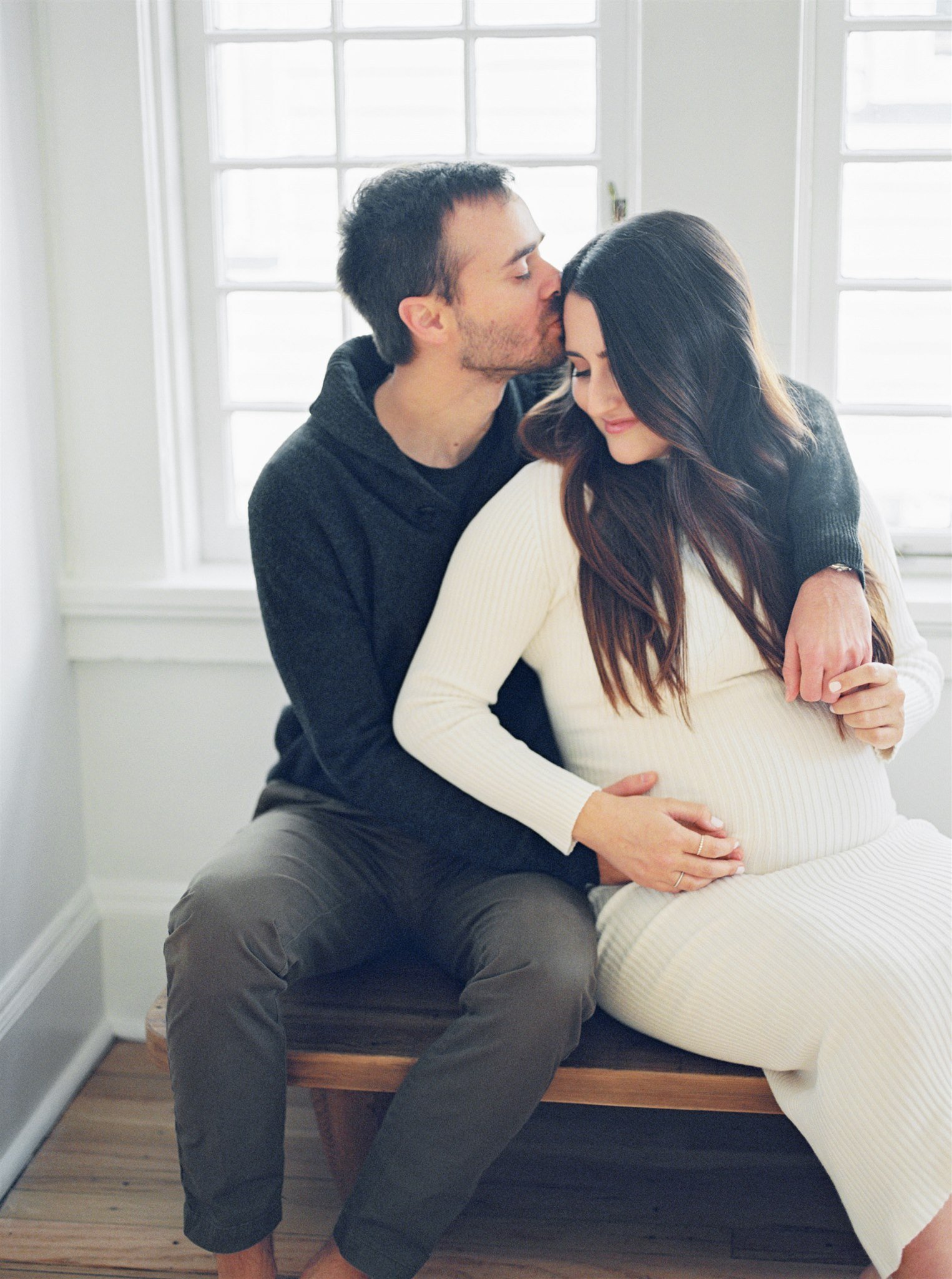 Man kissing woman's forehead during maternity session with Miami photographer 