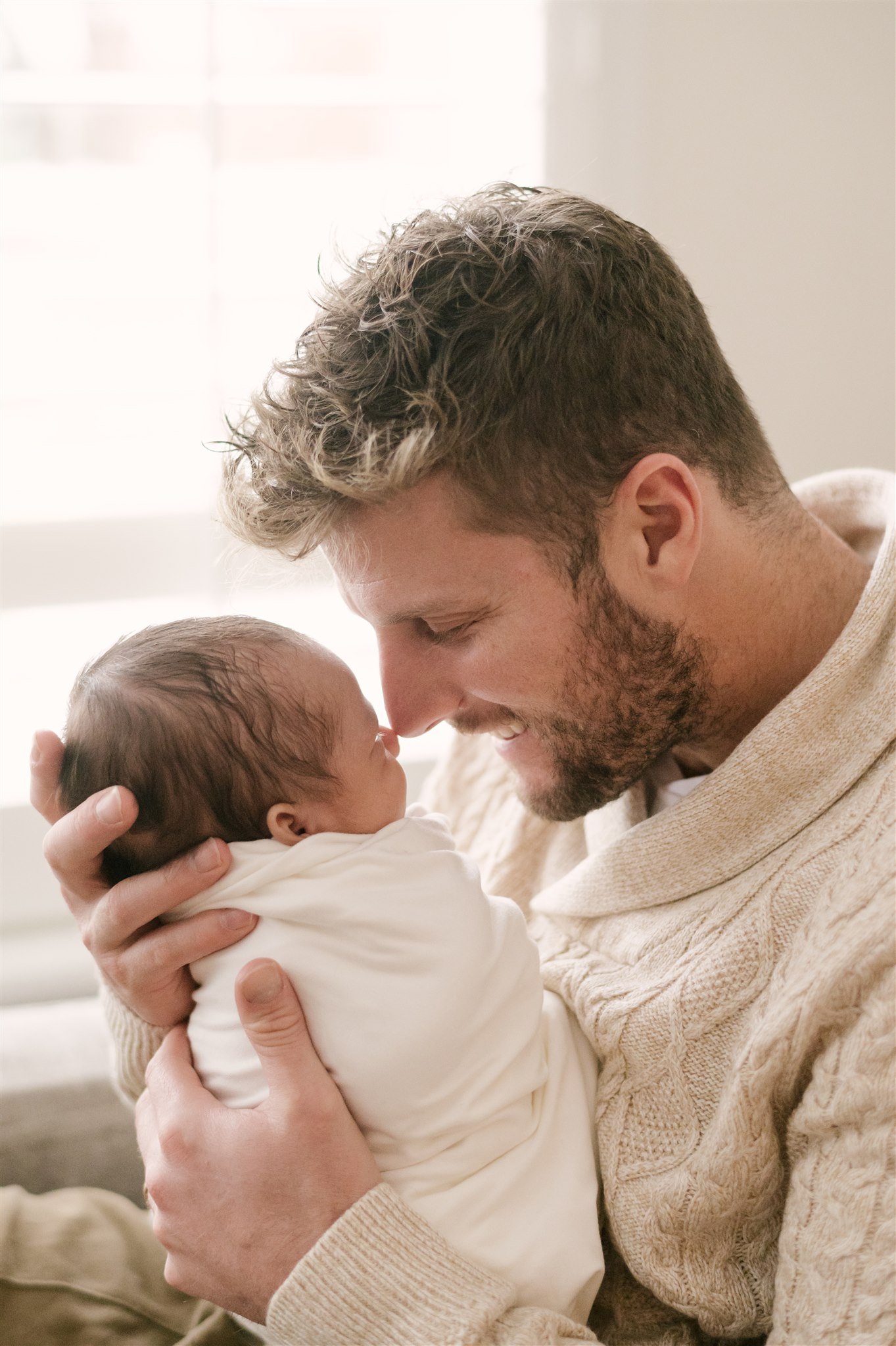 Dad and newborn touching noses during newborn shoot