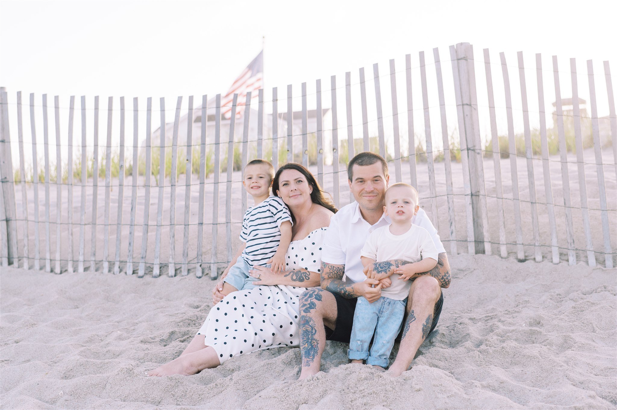 Family sitting on beach during family session with NKB Photo