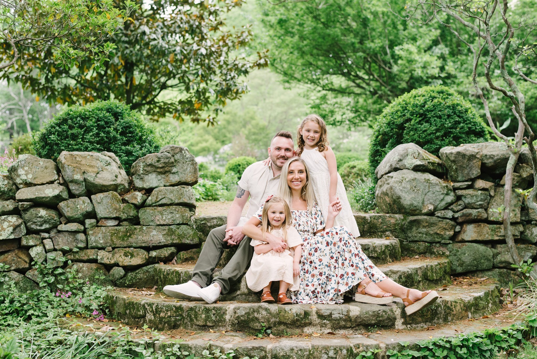 Family sitting on stone steps in garden during Parkland family session
