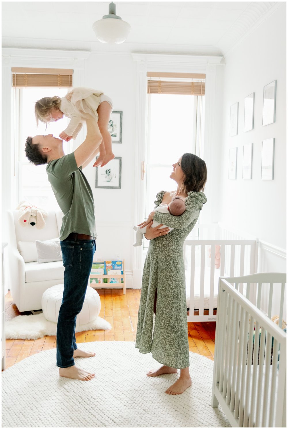 Dad holding toddler in the air while mom holds newborn during session with Fort Lauderdale photographer | NKB Photo