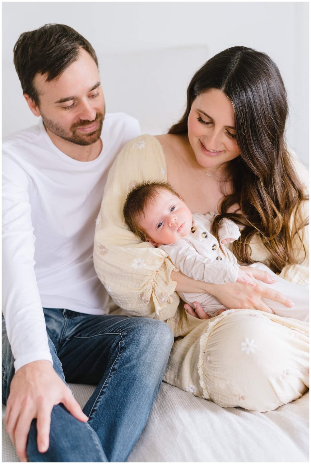 Mom holding newborn with dad next to her during newborn session | NKB Photo