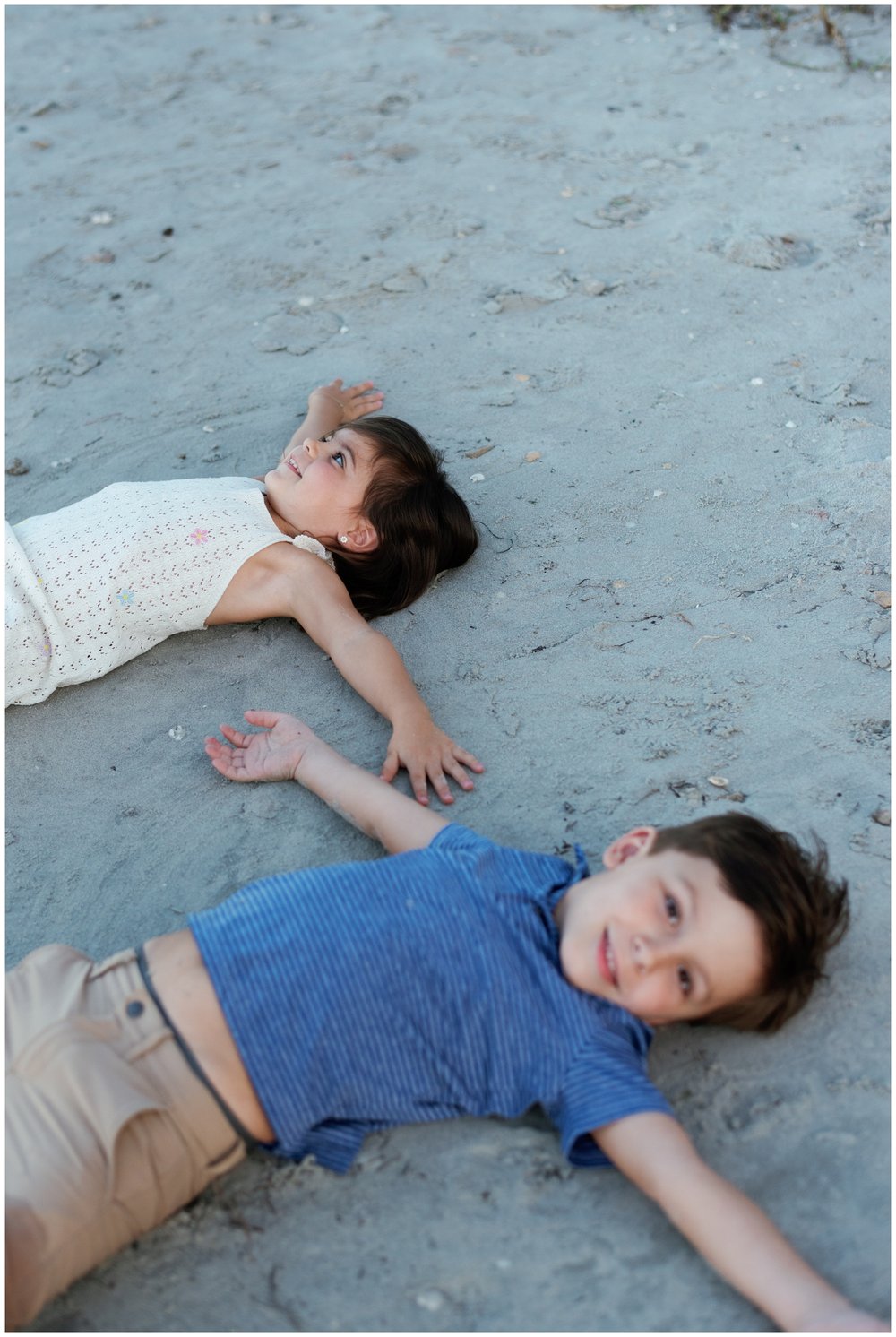 Young kids laying on sand on beach in Jupiter, FL | NKB Photo