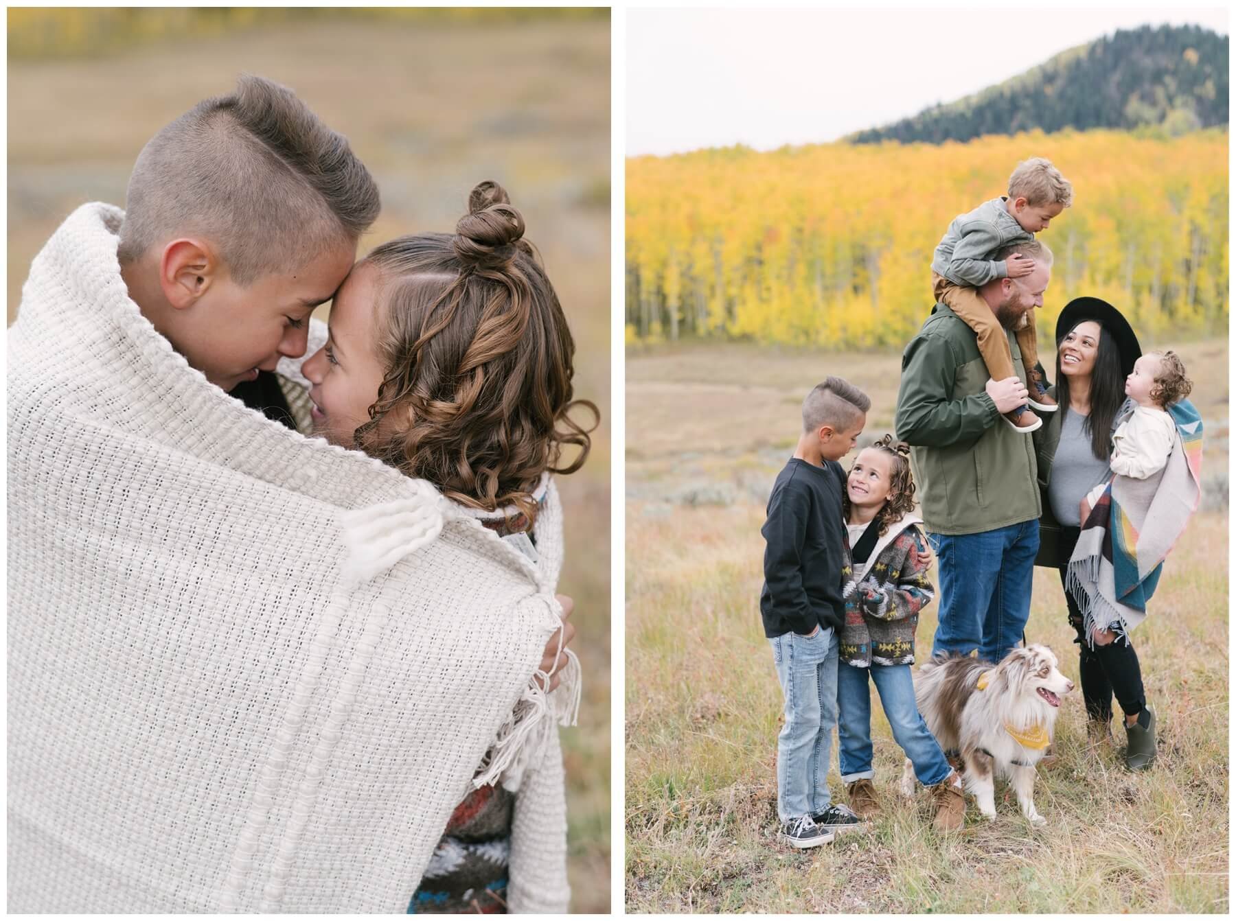 Brother and sister hugging under blanket and family standing in field in mountains with dog during session with NKB Photo