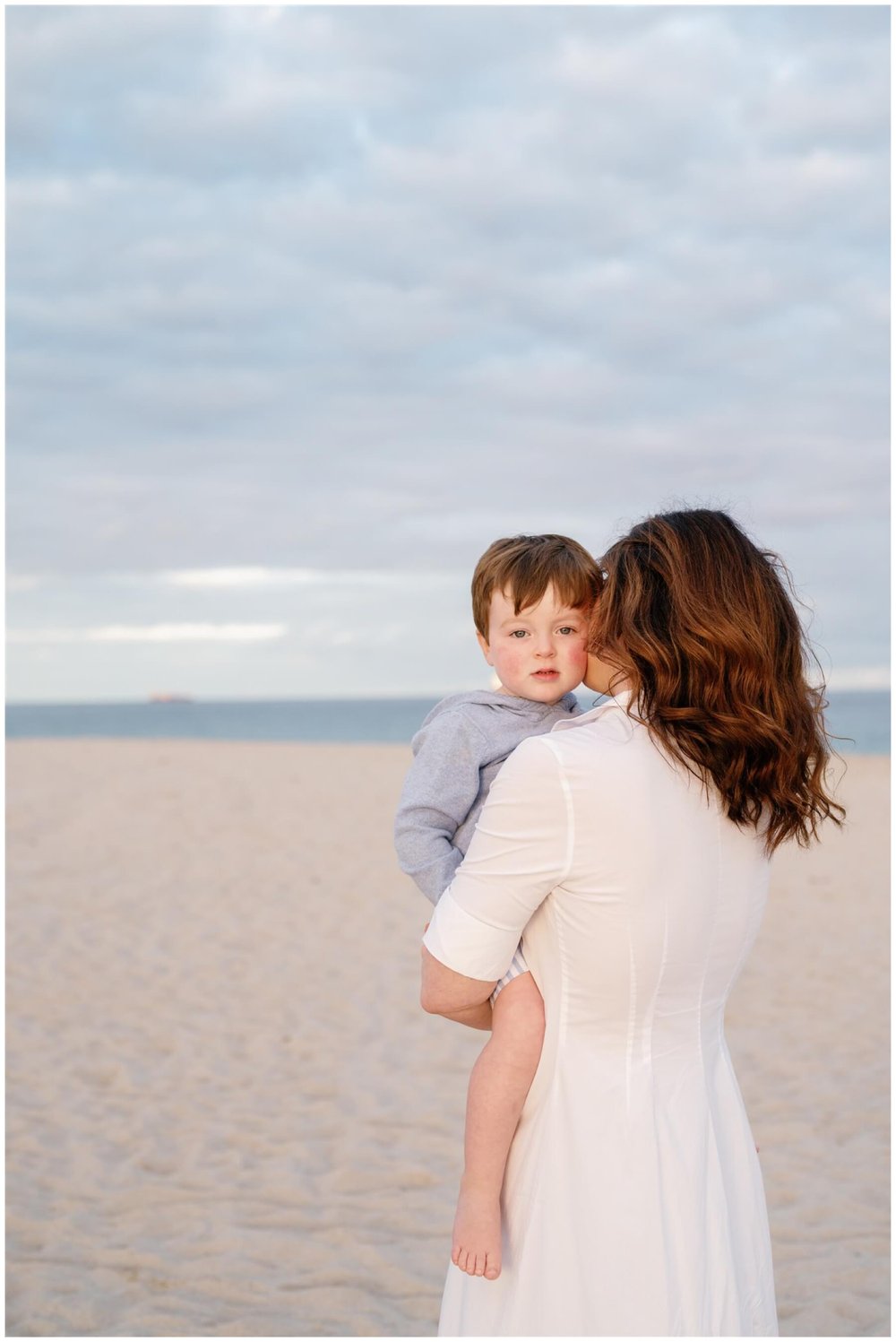 Mom holding toddler on beach during shoot with Fort Lauderdale Family Photographer | NKB Photo