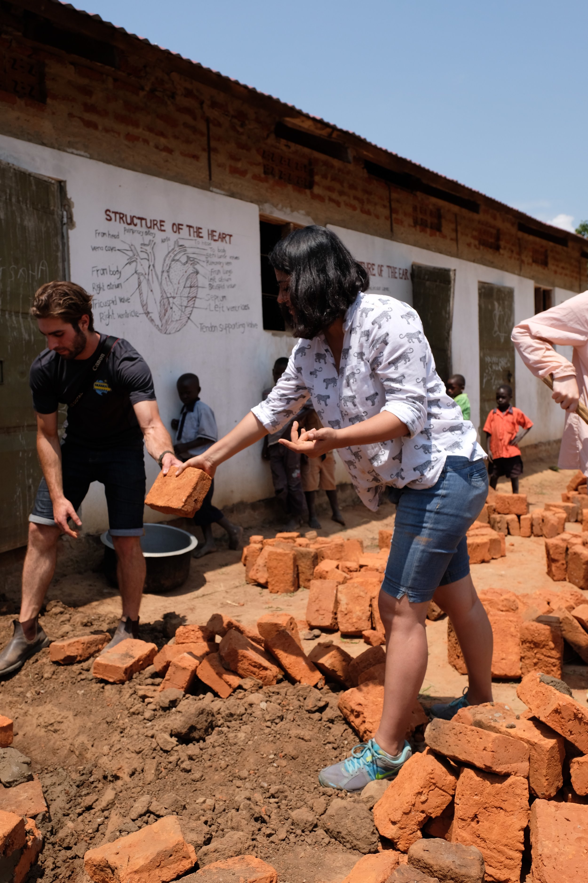 Aaron and I pass one another bricks to help with the construction of our water catchment system. 