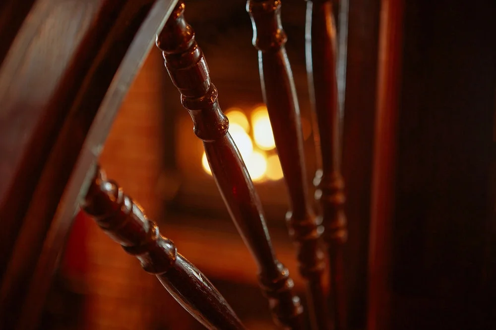 Surrounded by warm mahogany and the glow of the fireplace