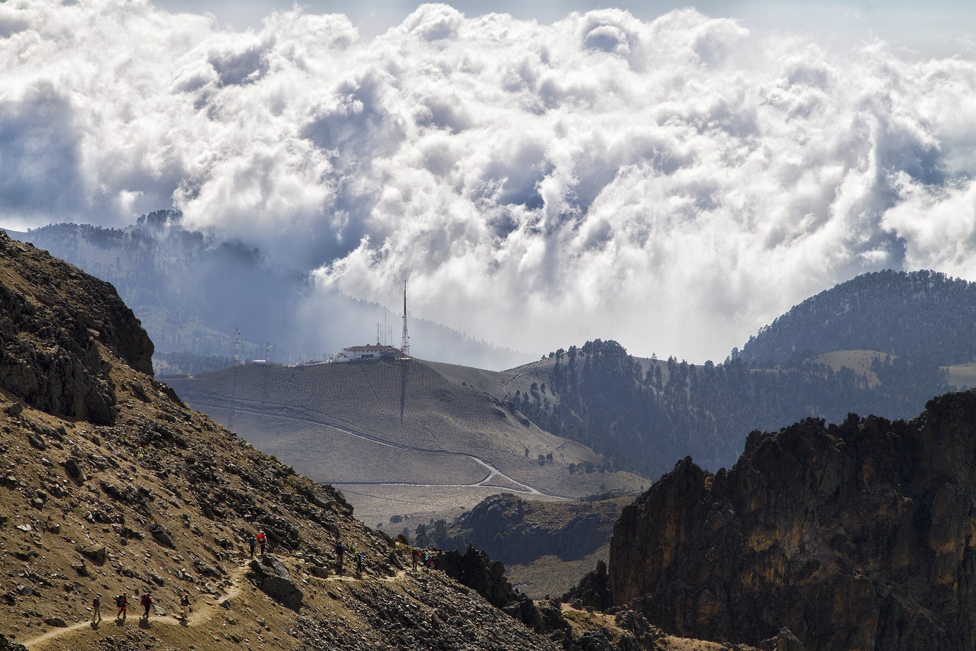  A moody bank of clouds begins to burst over the volcanic range’s foothills. The terrestrial levee can only sustain so much.&nbsp; 