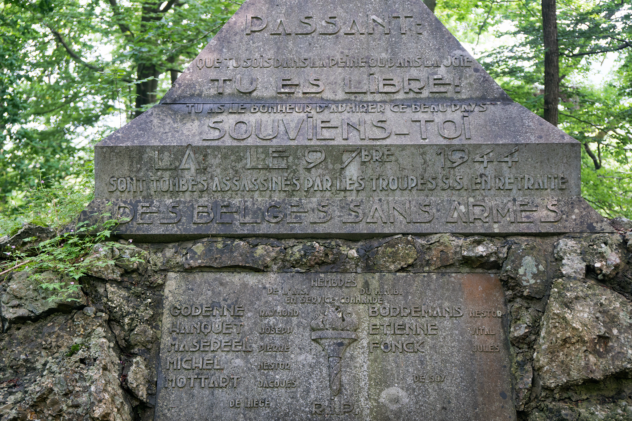 “Passerby: Whether in pain or in joy, you are free. You have the good fortune of admiring this beautiful land. Remember this. Here, on September 9th, 1944, unarmed Belgians were assassinated by retreating SS troops.”