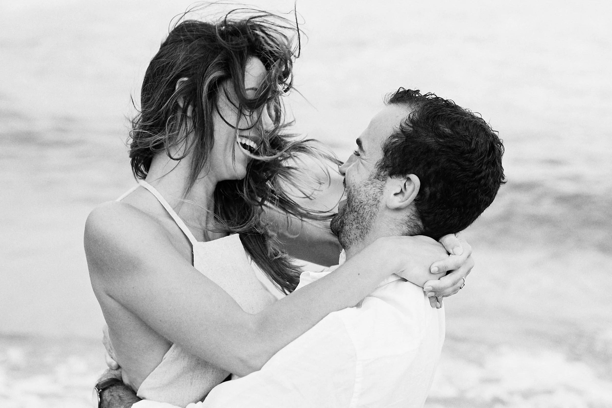 Black and white of couple playing in ocean at Palm Beach