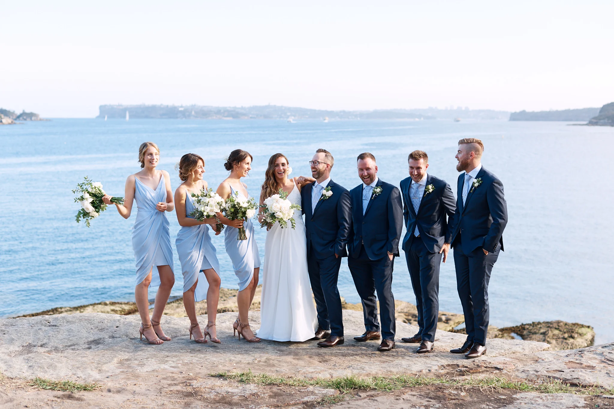 Bridal party laughing by ocean.jpg