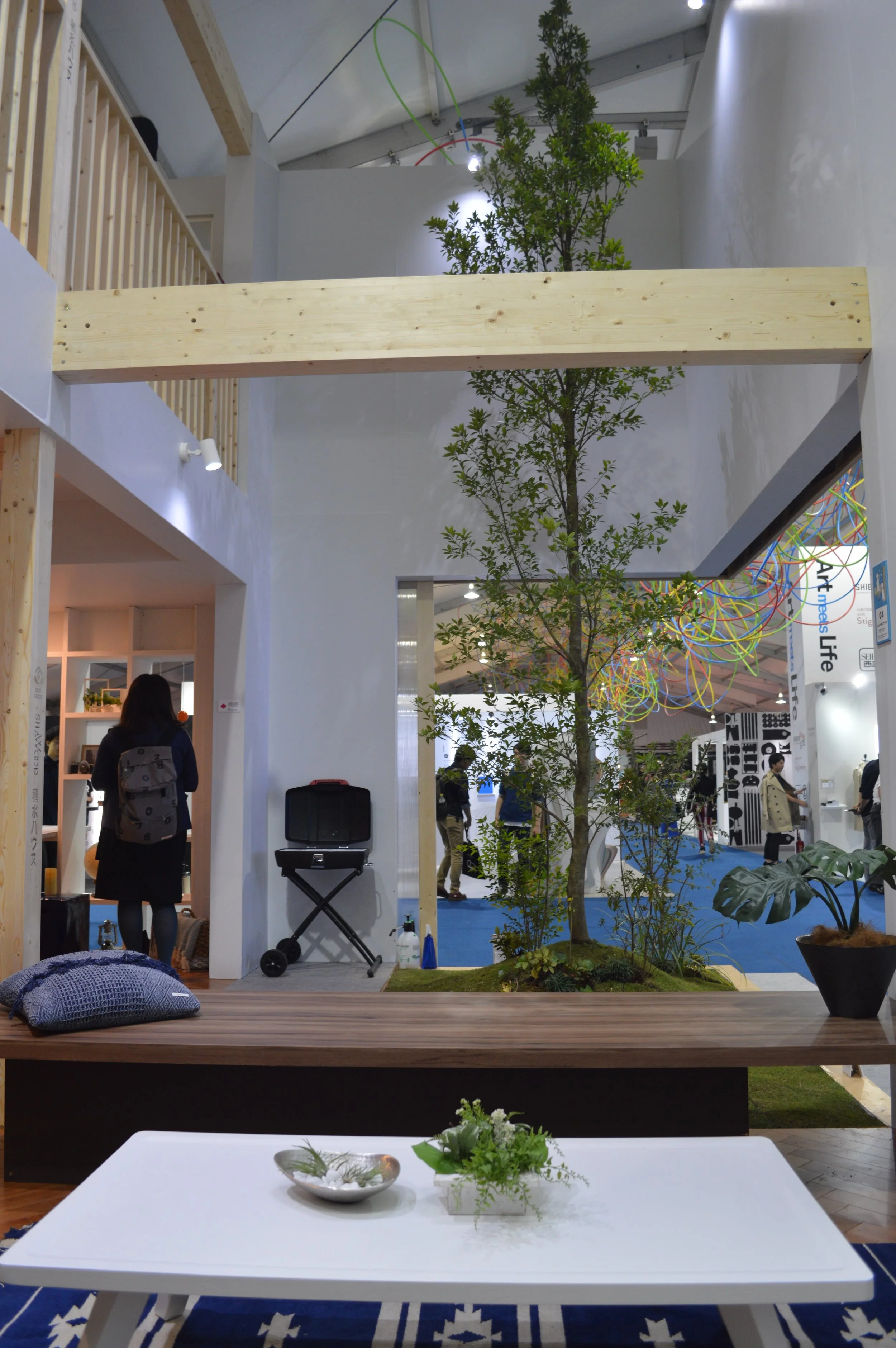 Tokidoki-oide Terrace: A flexible courtyard with a sculptural tree. It becomes a private space by closing the outer doors or an open space by leaving the doors open. This is the view from the swinging sofa in the living room.