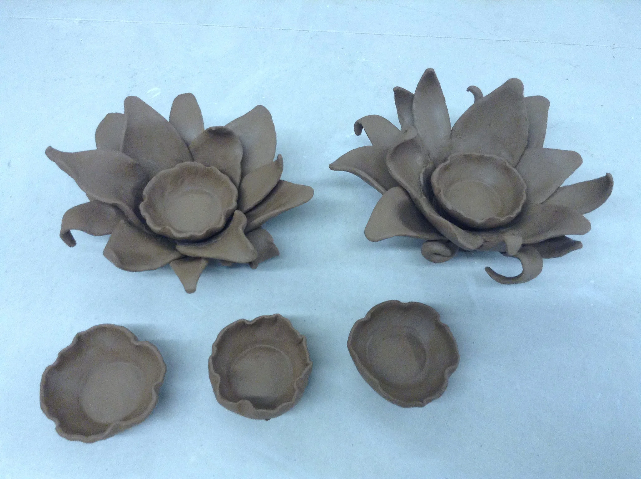 Two flower forms, shown with three separate candle-holding cups.