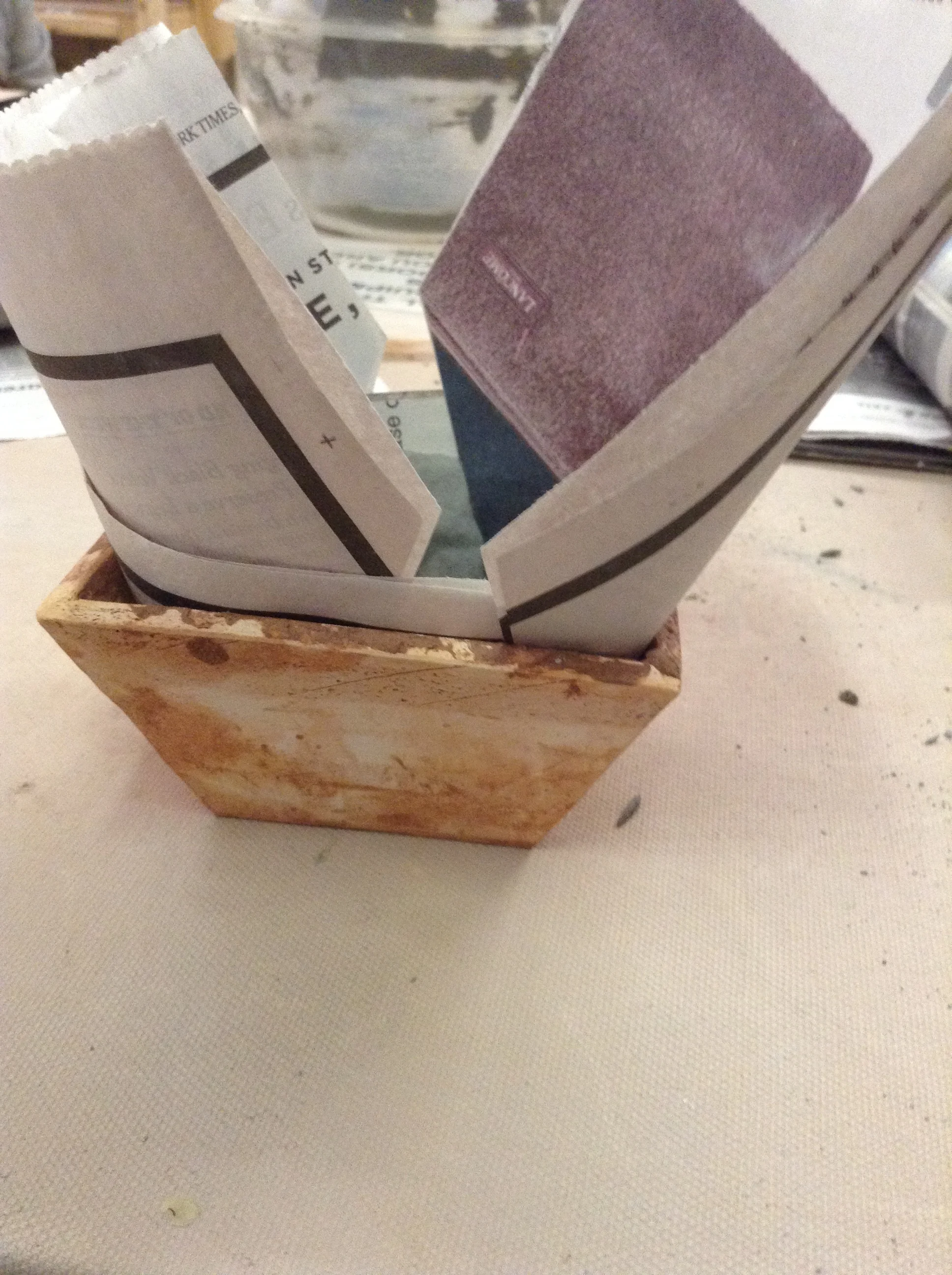 The orange-brown angled form underneath is just another clay box I built. Here I'm using it to hold the wet clay layers in an overlapping position until they dry enough to stay there.