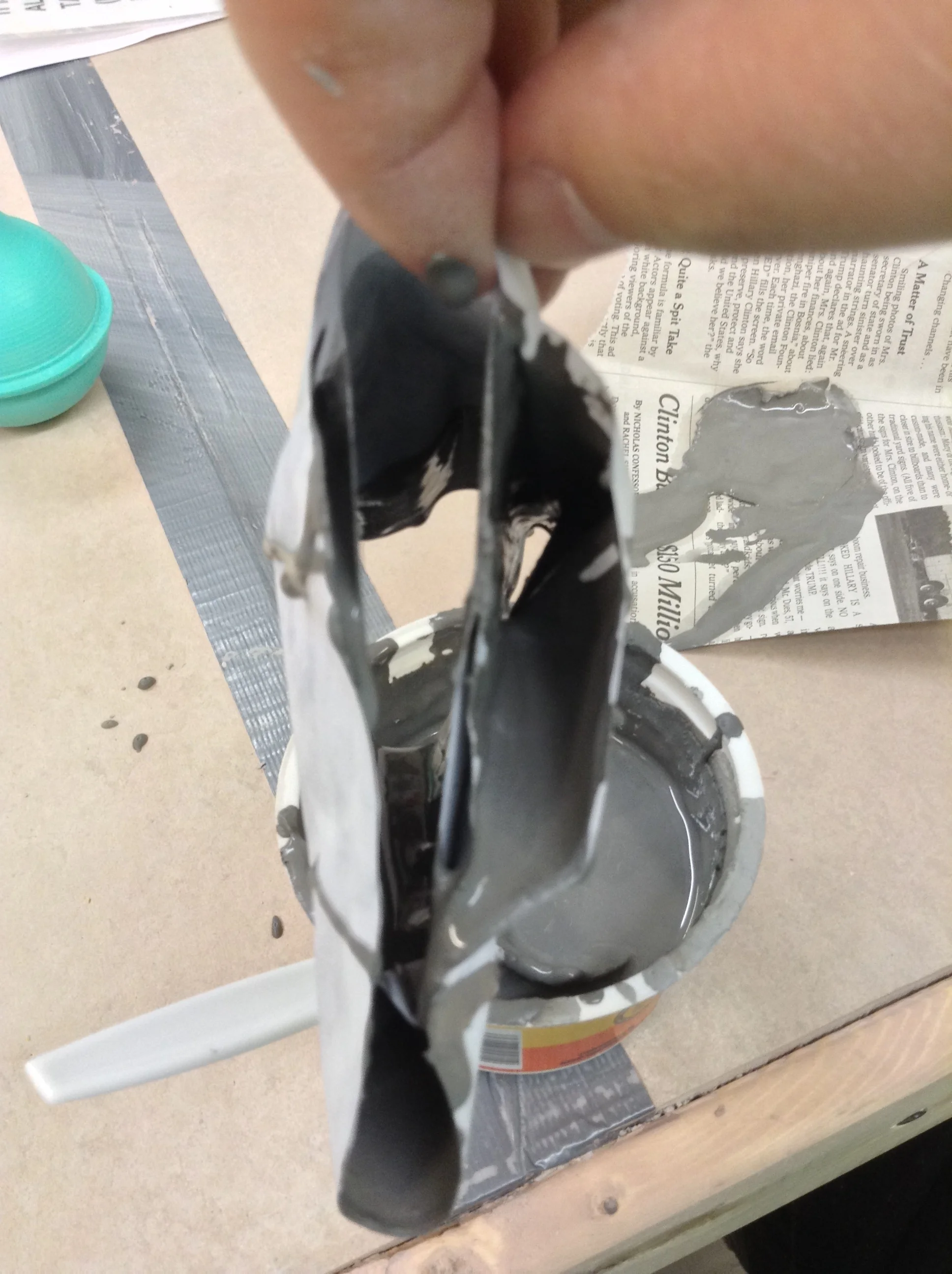Collapsed form raised off of table and held.
