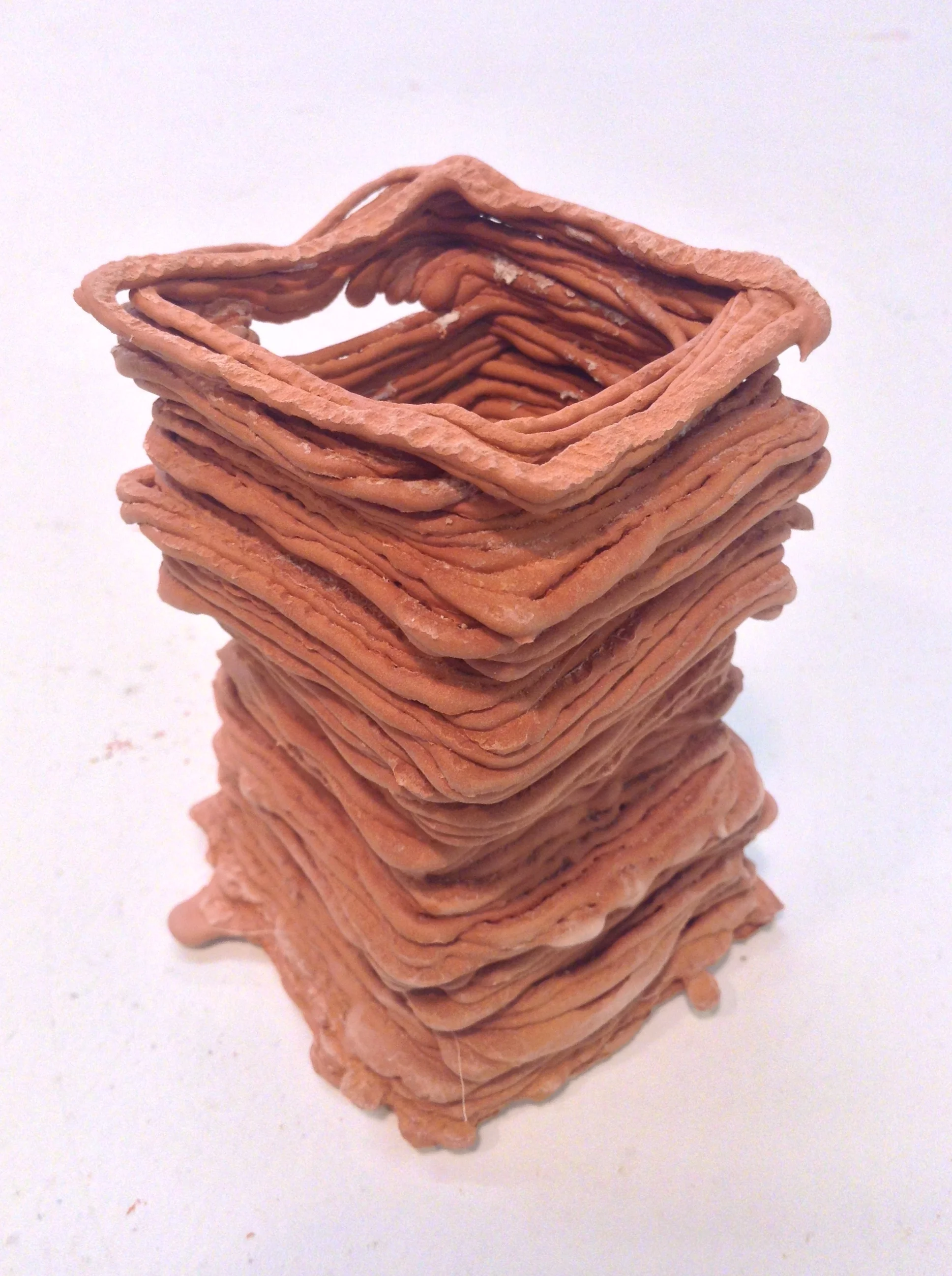 A tall stack of slip-trailed layers. Low-fire clay, cone 05 oxidation, unglazed.