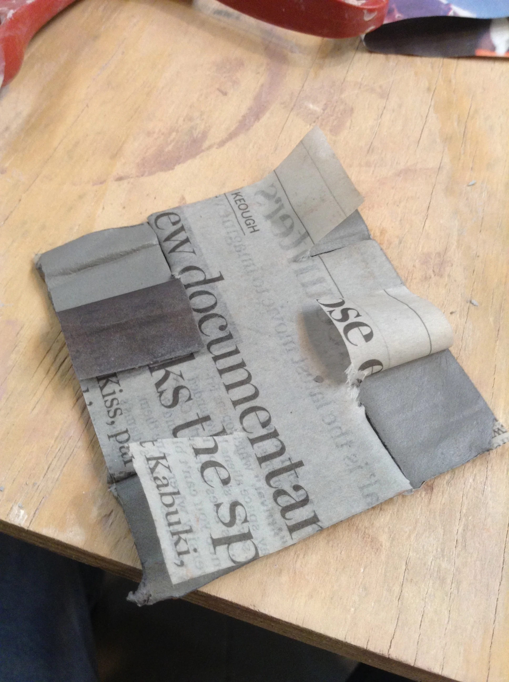 Four cuts from edges with plain scissors make slits, then one layer of paper is pulled back. These exposed squares will have matching exposed places on other side. These newly-exposed surfaces are almost self-adhesive. Whatever paper remains, helps hold the form stable while connecting happens in a few locations.