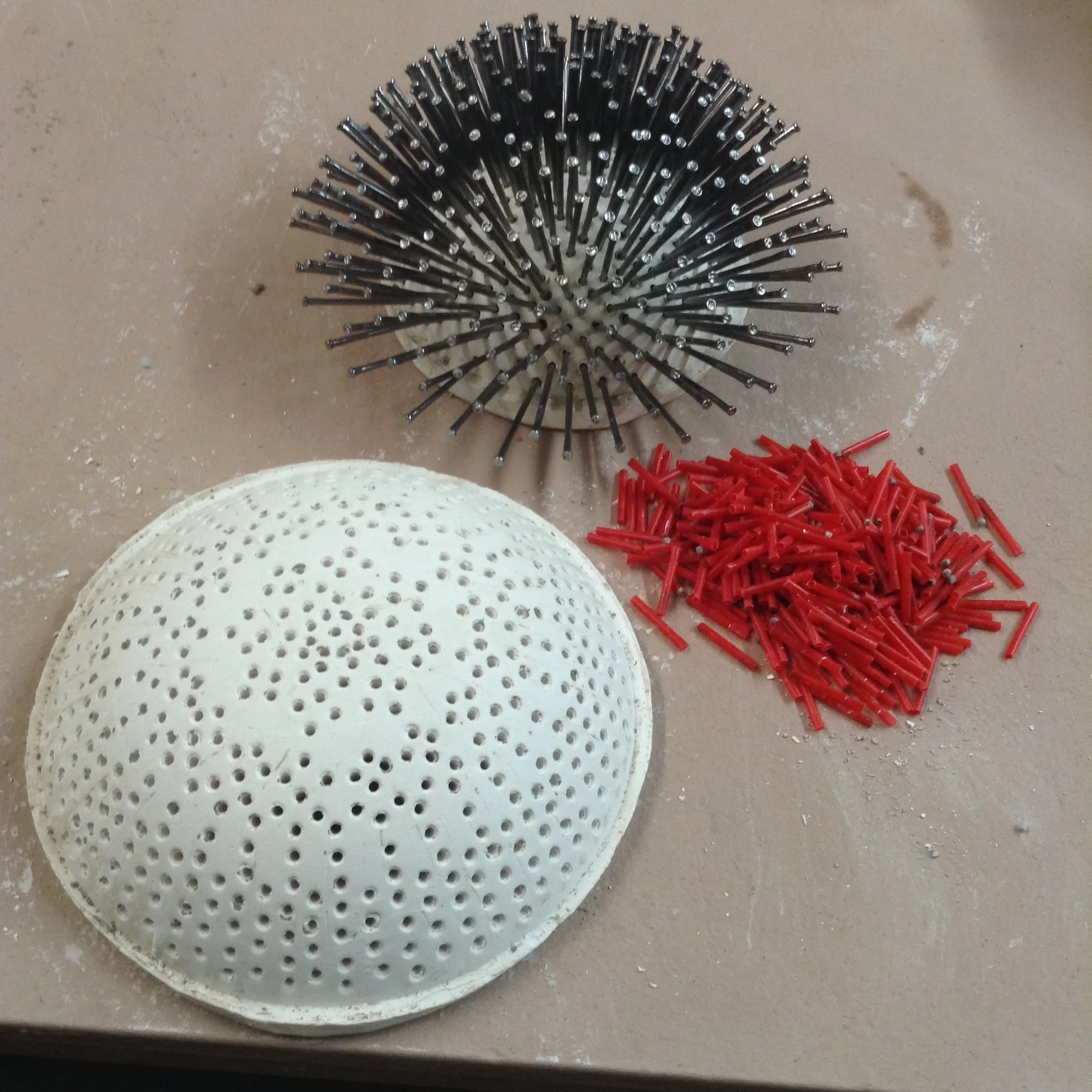Plaster dome shown here with all its stirrers pulled out. Smaller dome in back, made in similar way, shown with all holes filled with nails. This would make a very complicated winding. Much more likely to use a few nails in a simpler pattern.