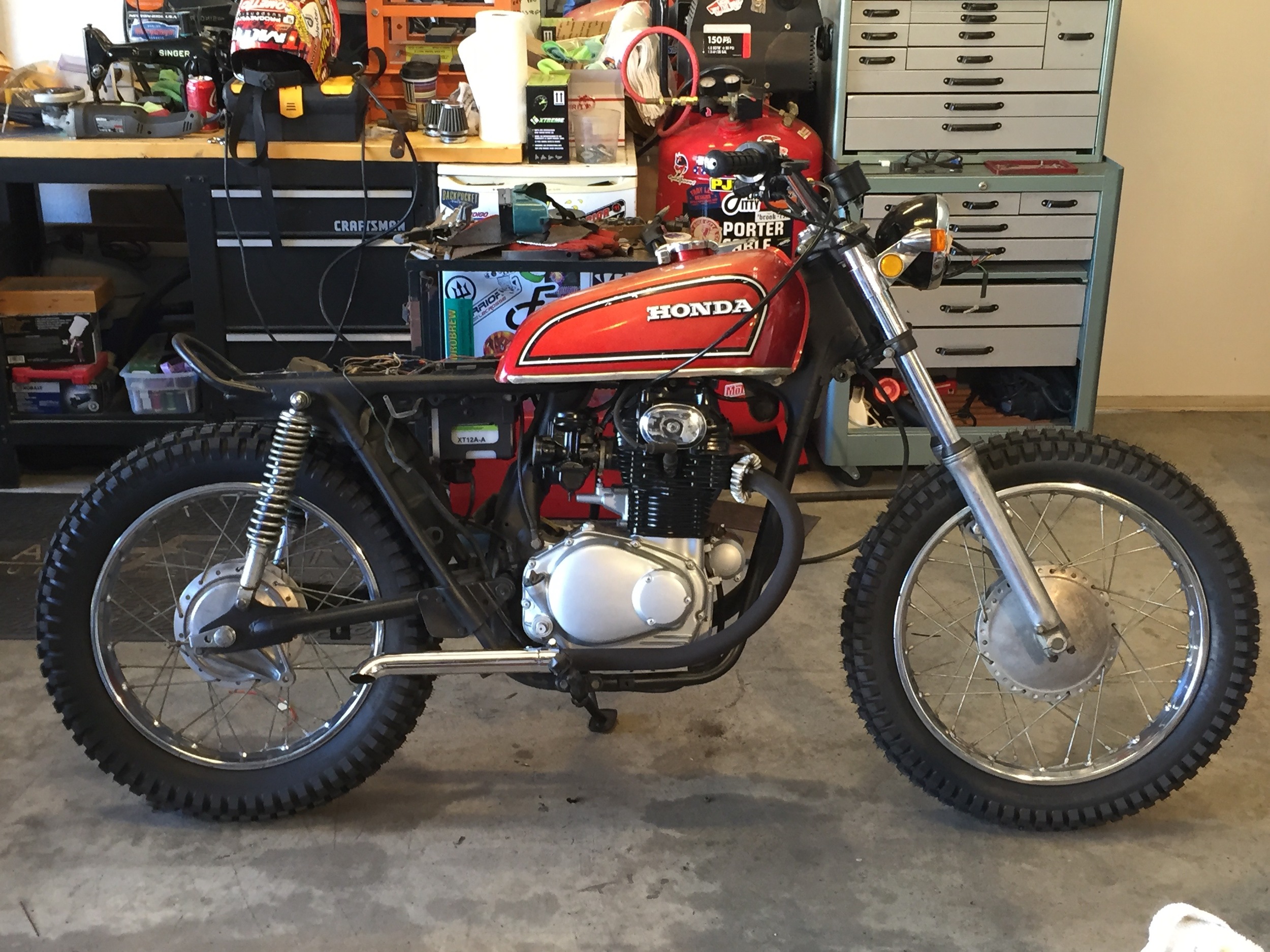 I found a nice CB360 tank on eBay. It has perfect patina and only required a relocation of the tank mounts on the frame. The rear seat hoop was chopped and modified to shorten the seat pan and eliminate the downward slope that the SL seat had stock. Some simple turned down mufflers with removable baffles make this little twin sound mean when you twist the throttle. The trials tires really keep it looking vintage moto.