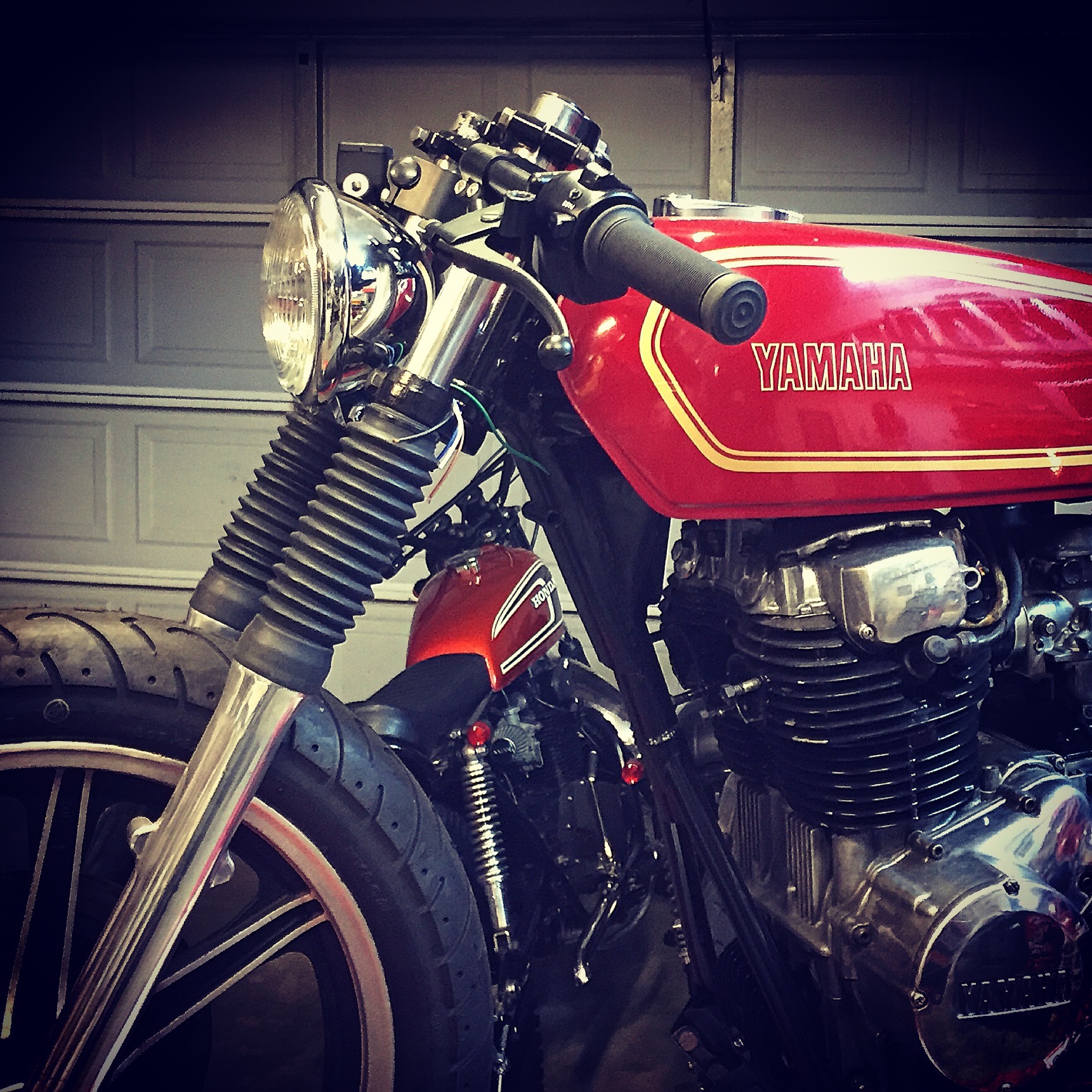 We had an old Honda SL350 headlight bucket laying around. On a whim I set it between the forks and fell in love with how it looked. With custom bracket we were able to tuck it in with a bottom mount. It instantly made the bike look mean!
